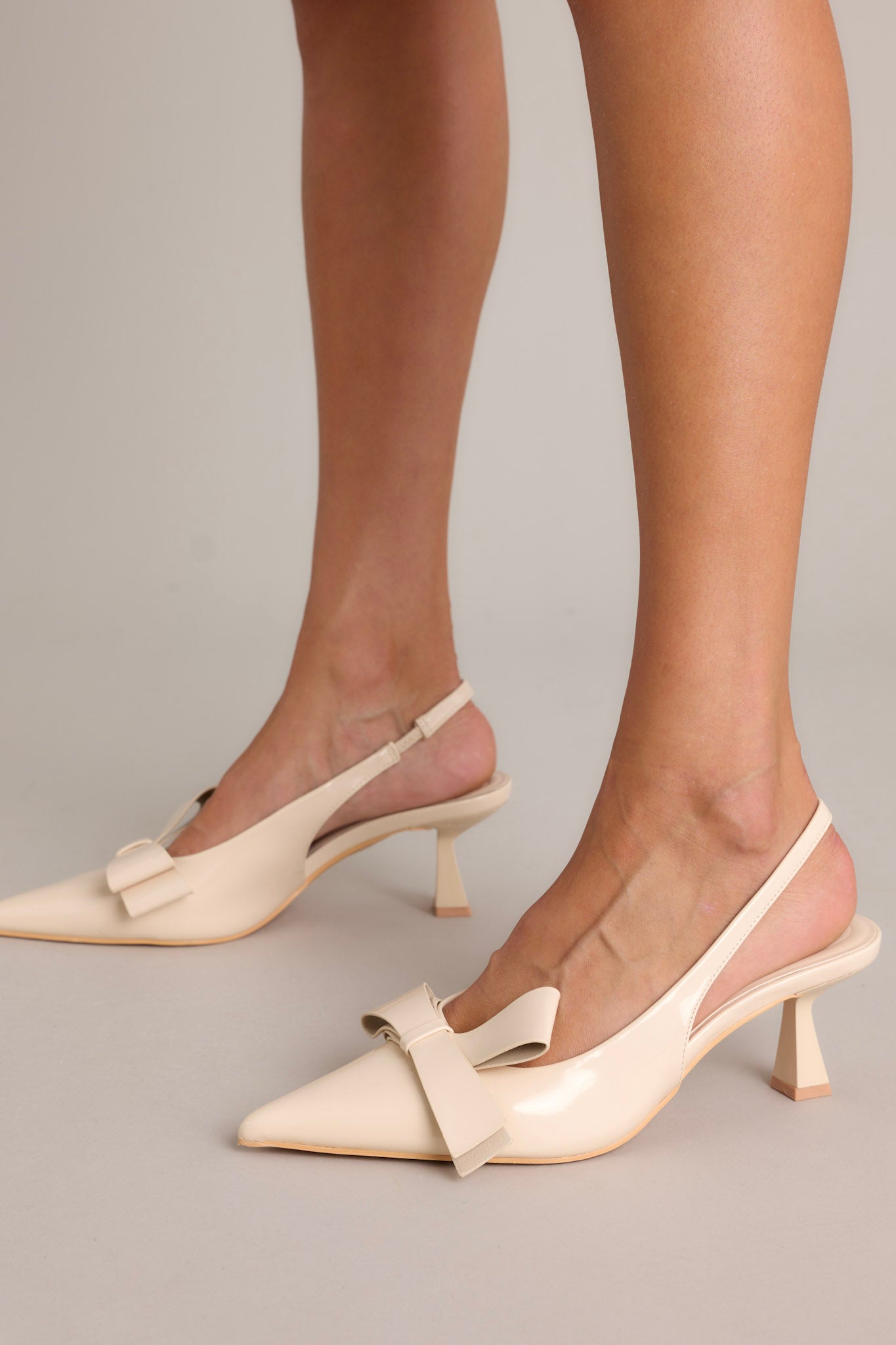 These light beige heels feature a pointed toe,a gorgeous bow detail, slingback strap, and a short kitten heel.