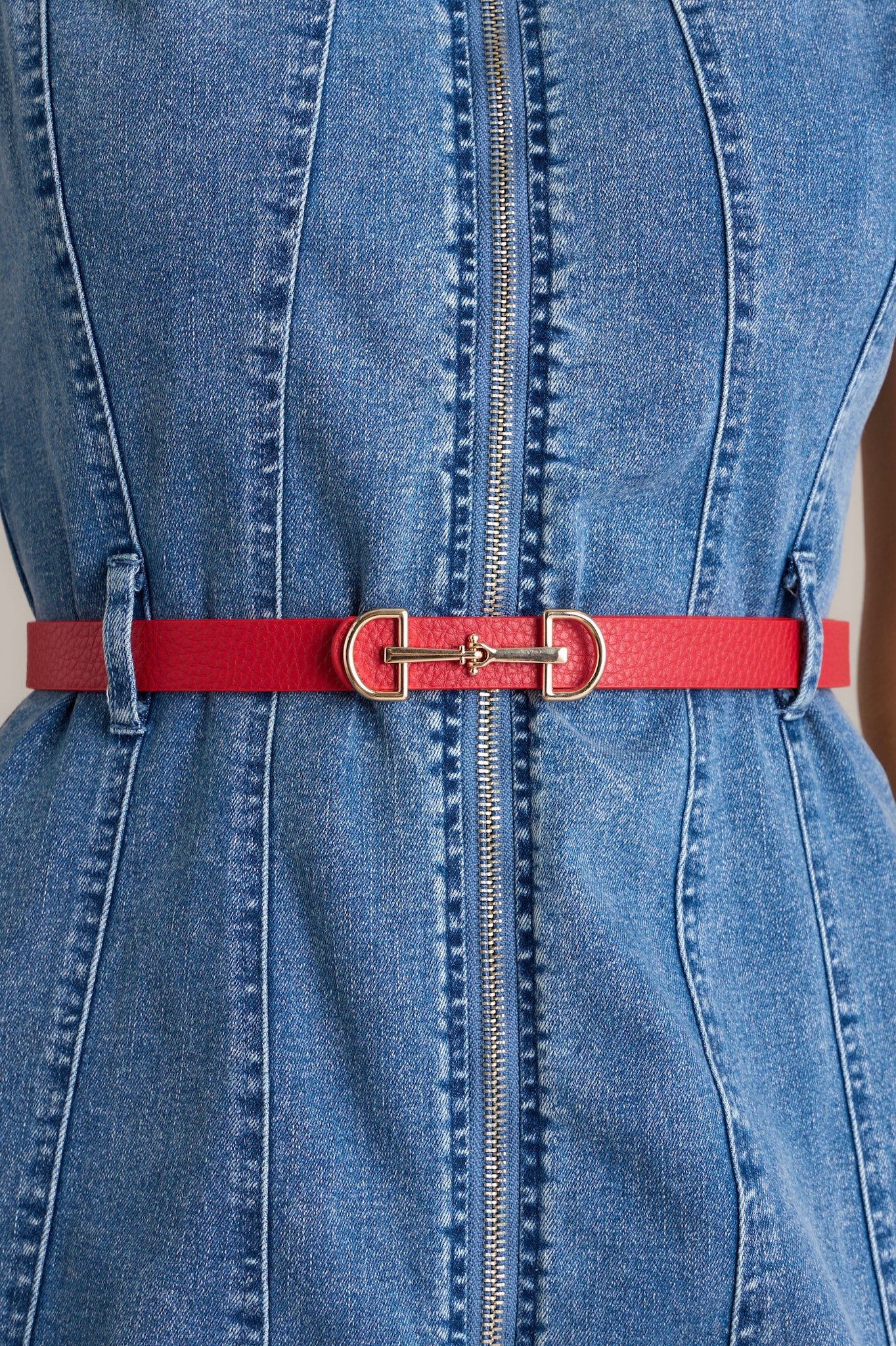 This red belt features gold hardware, an anchor closure, and a textured design.