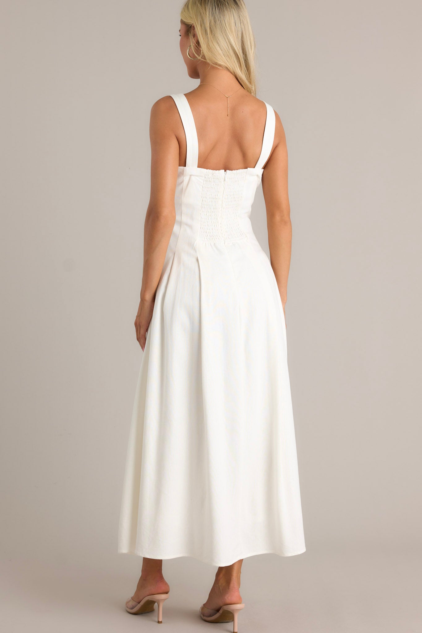 Back view of the ivory dress highlighting the smock insert, the discrete back zipper, and the flowing silhouette.