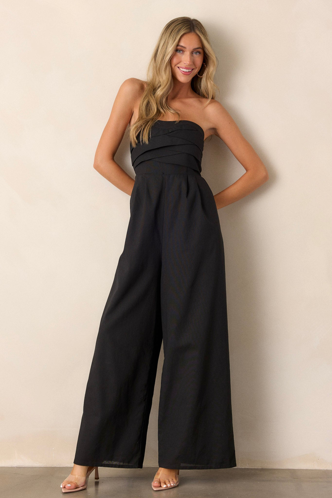 Full length view of the jumpsuit featuring a smocked back, wide leg bottoms, and a stretchy band on the bust for support