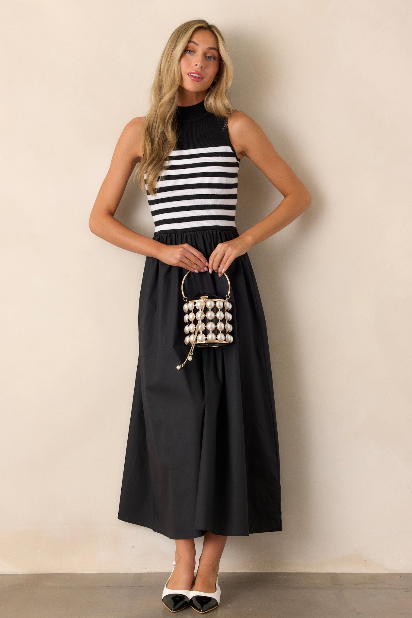 Front view of a black stripe maxi dress featuring a high neckline, a striped sweater bodice, and a flowy skirt.