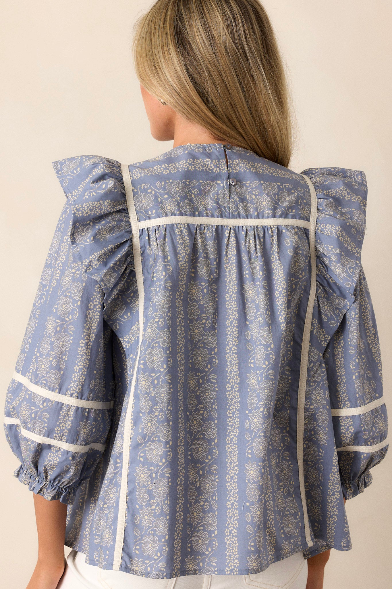 Back view of the top highlighting the ruffle sleeve design and the continuity of the white trim and 3/4 sleeves.