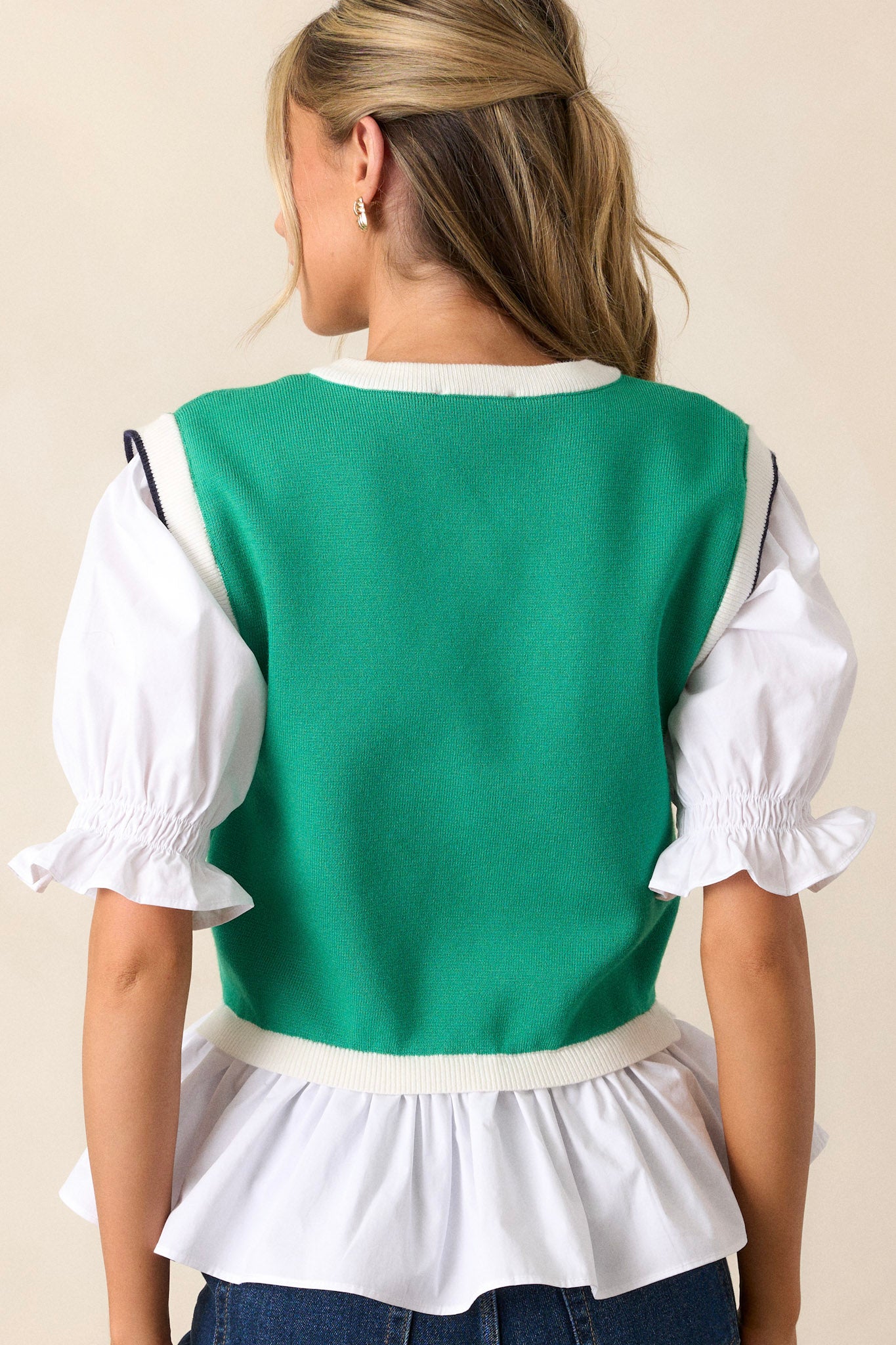 Back view of the green top showcasing the simplicity of the durable green material, with a focus on the puff sleeves from behind.