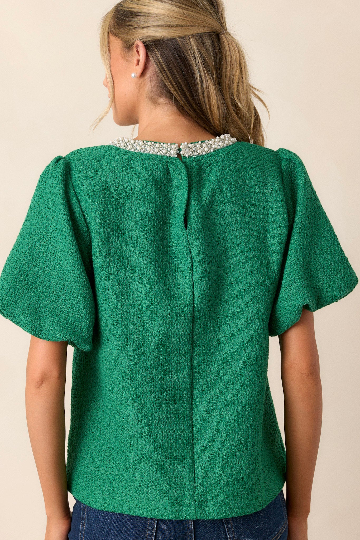 Back view of the jade green top highlighting the clean, uninterrupted silhouette, allowing the jewel embellishments on the collar to stand out.