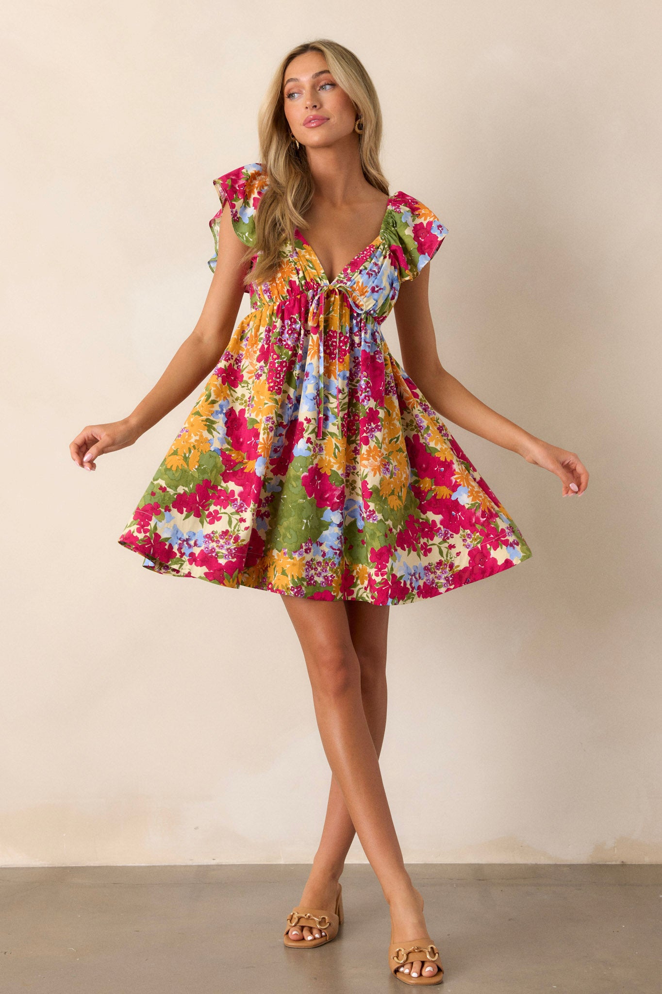 This floral dress features a smocked back with a functional zipper, two functional pockets, and ruffle sleeves.