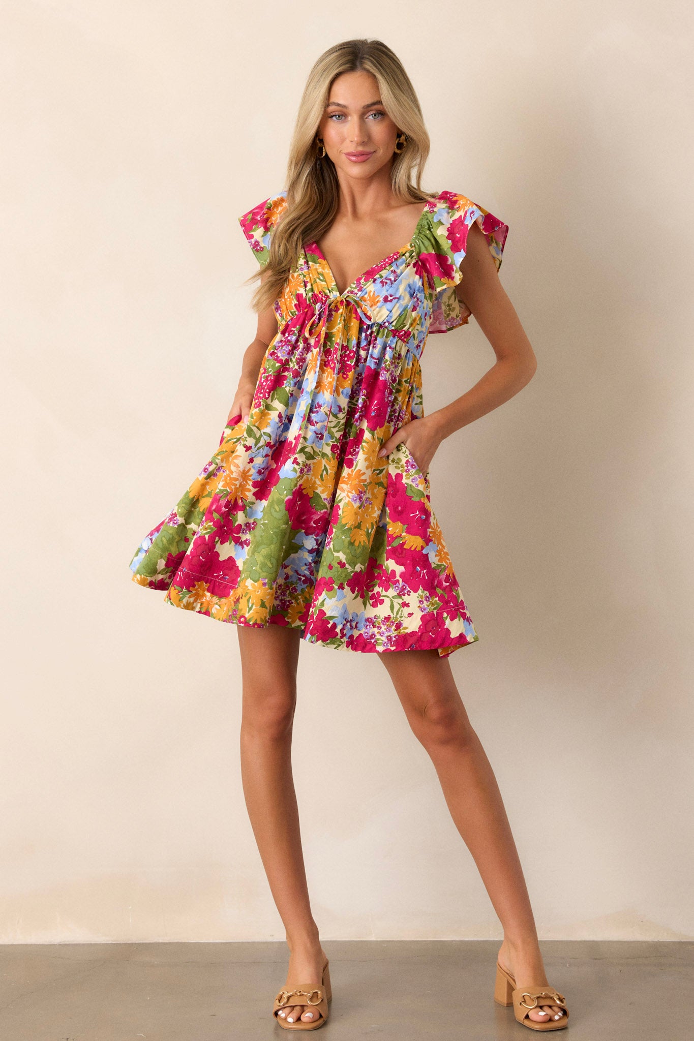 Full length view of the floral dress featuring a smocked back with a functional zipper, two functional pockets, and ruffle sleeves