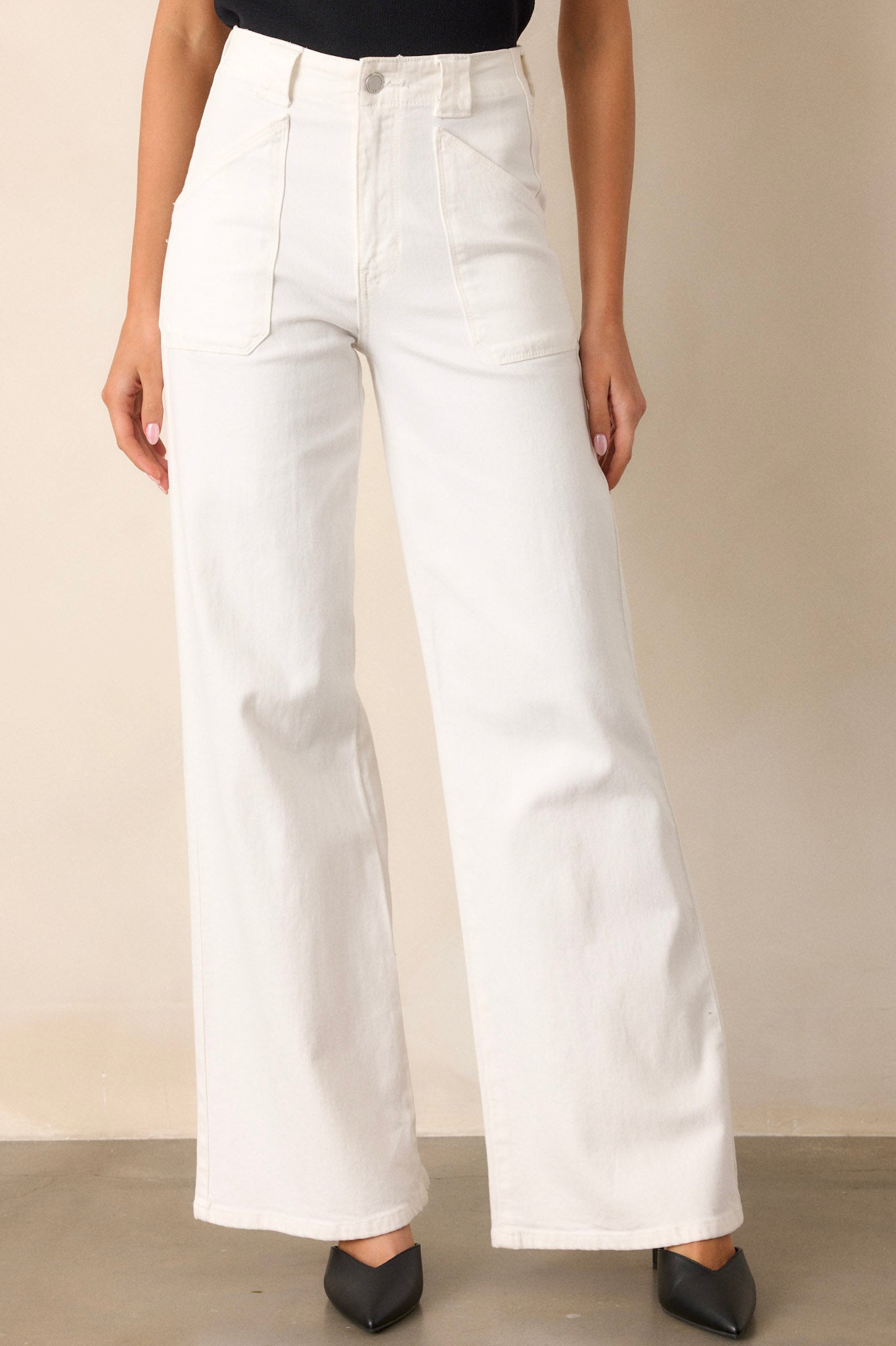 Front view of these white jeans that feature a high waisted design, classic button & zipper closure, belt loops, functional front patch pockets, and a flare leg.