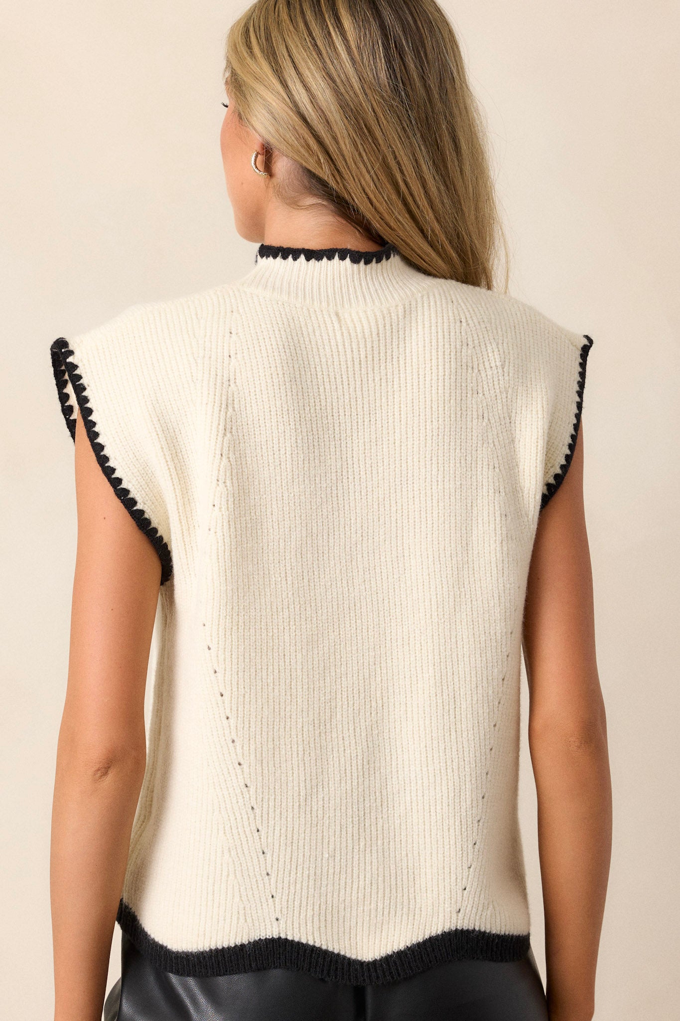 Back view of the beige sweater top highlighting the relaxed fit and the clean lines of the soft knitted fabric, with a subtle view of the ribbed crew neckline and cap sleeves