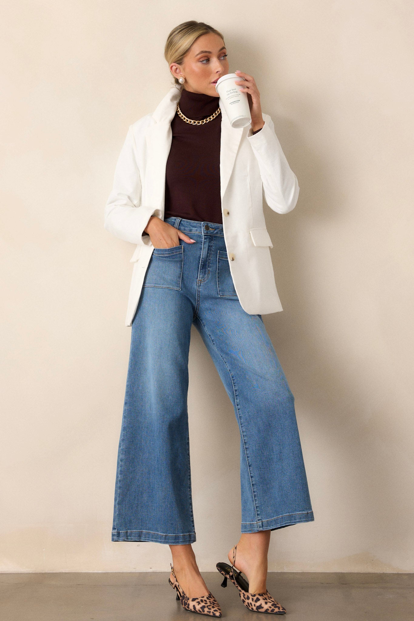 This white blazer features a collared neckline, a functional half button front, padded shoulders and long sleeves.