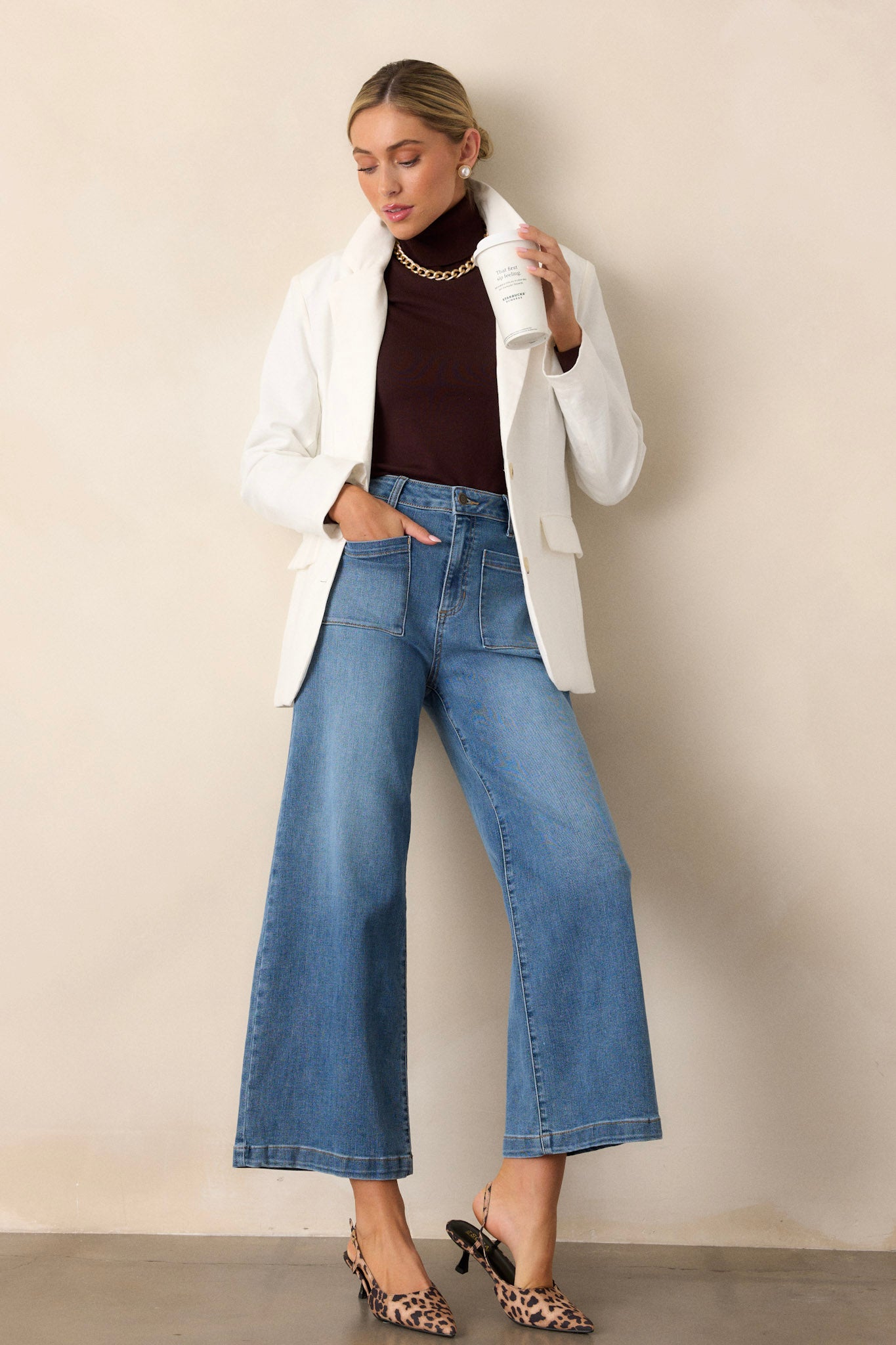 Full-length view of a model wearing medium wash jeans, emphasizing the wide leg design, functional belt loops, and classic denim style.