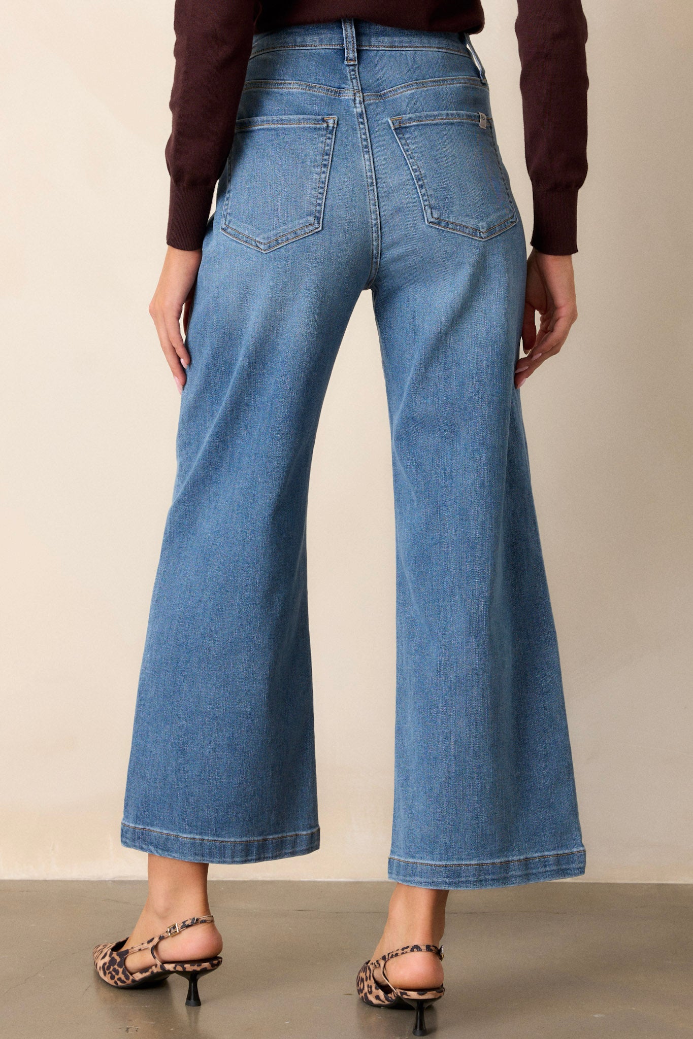 Back view of medium wash jeans highlighting the functional back pockets, belt loops, and the wide leg cut.