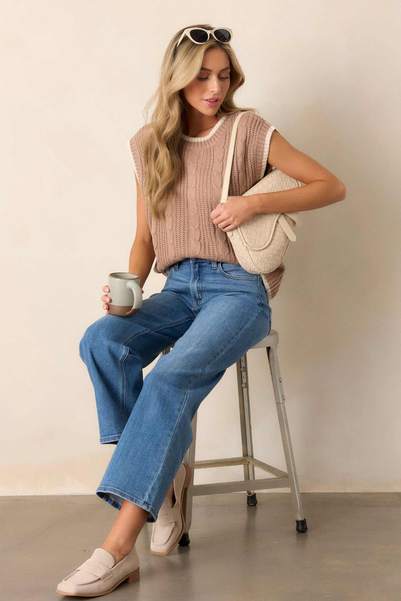 This knit sweater top features a high rounded neckline, a soft knit texture, cap sleeves and an ivory trim.