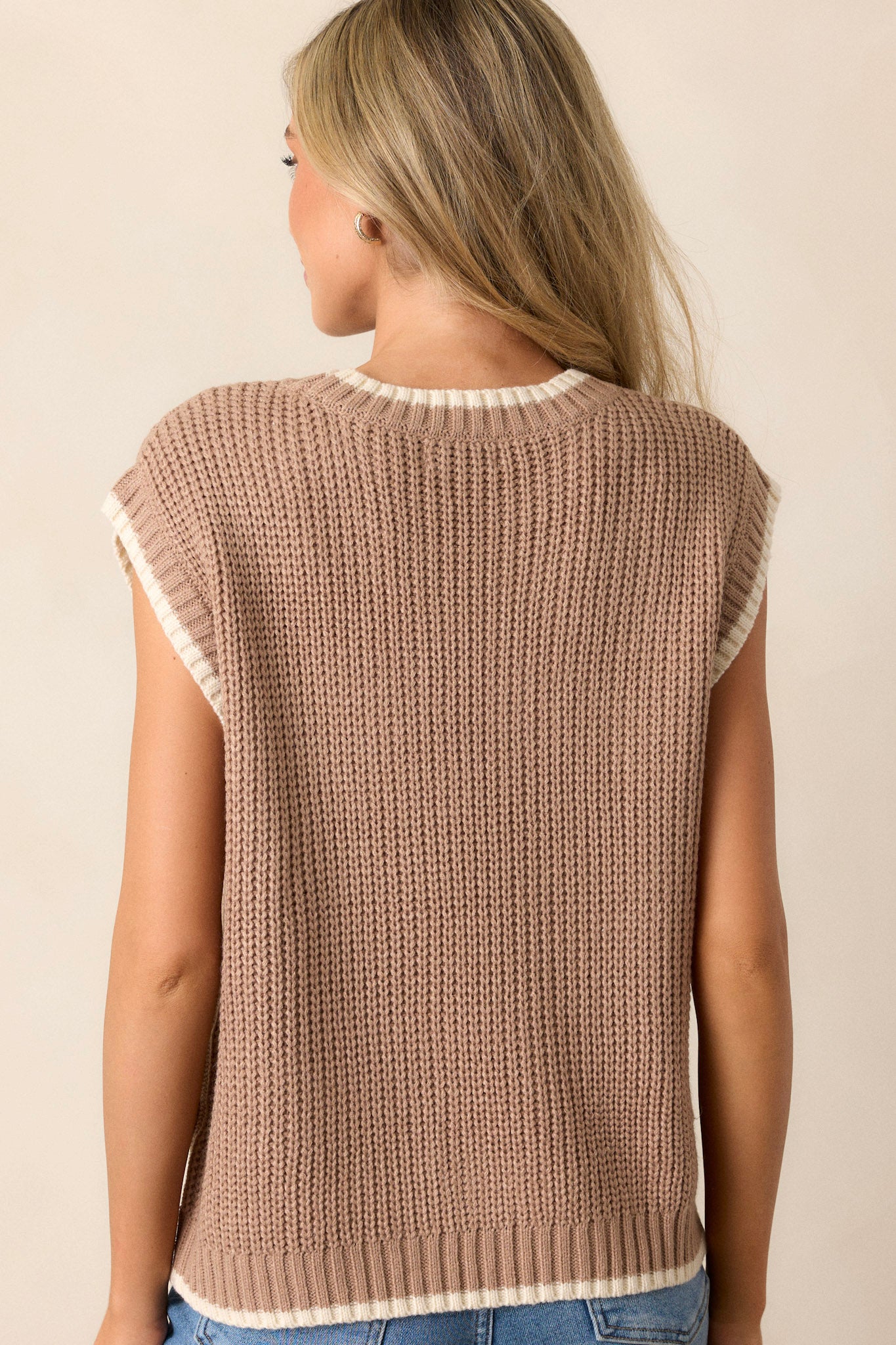 Back view of a knit sweater top highlighting the overall fit, cap sleeves, and the ivory trim.