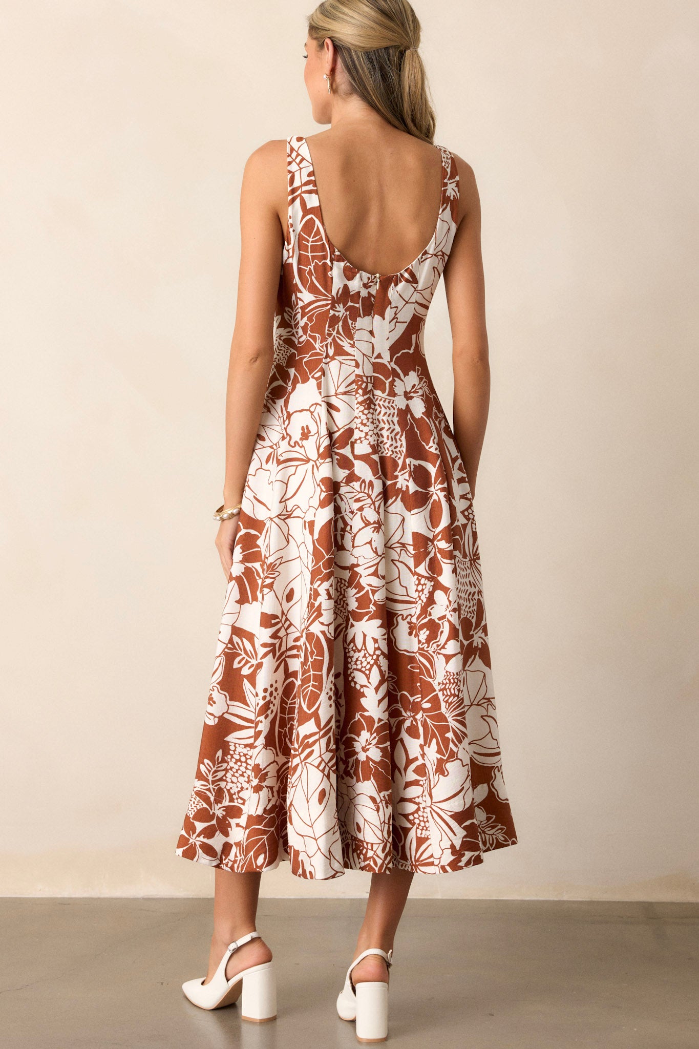 Back view of the floral dress highlighting the functional zipper and the continuation of the pleated design