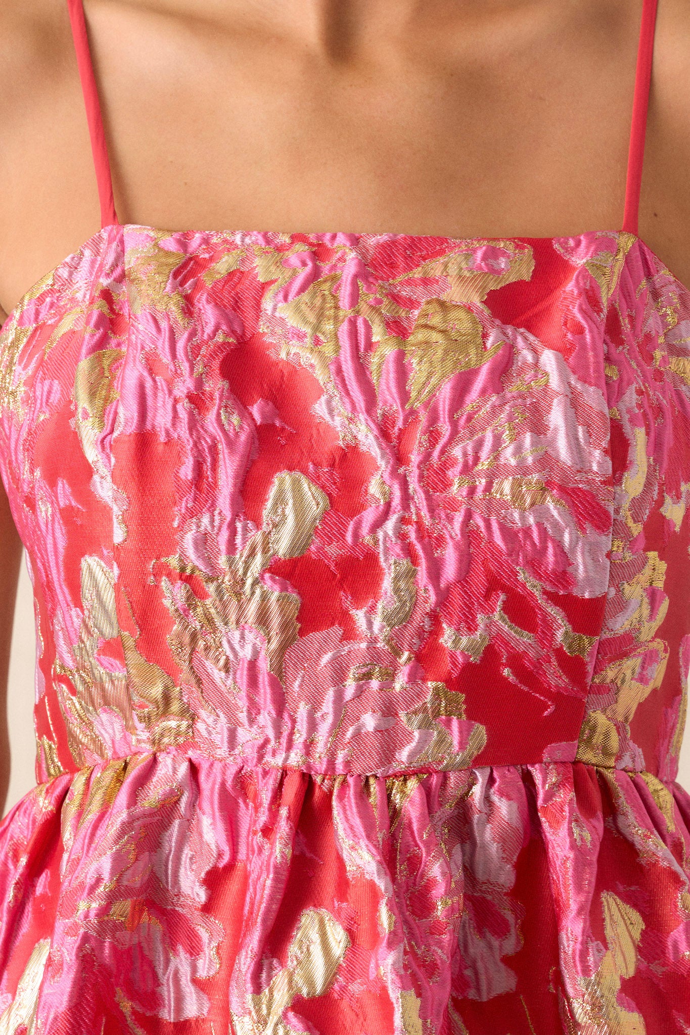 Detailed view of the floral jacquard fabric on the pink dress, emphasizing the intricate floral pattern and texture.