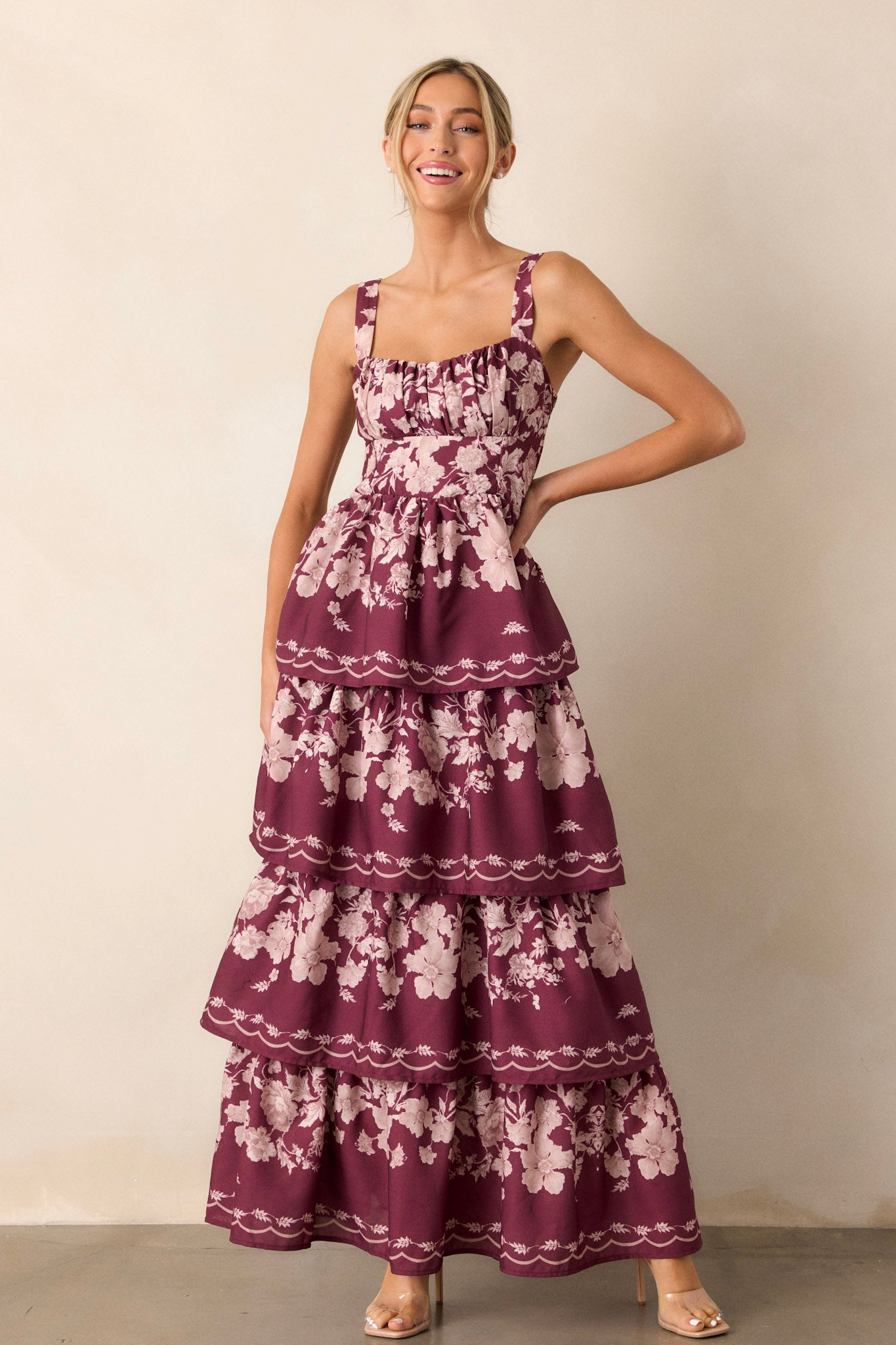 Front view of a wine-colored dress featuring four flowy tiers, adjustable straps, and a back functional zipper.