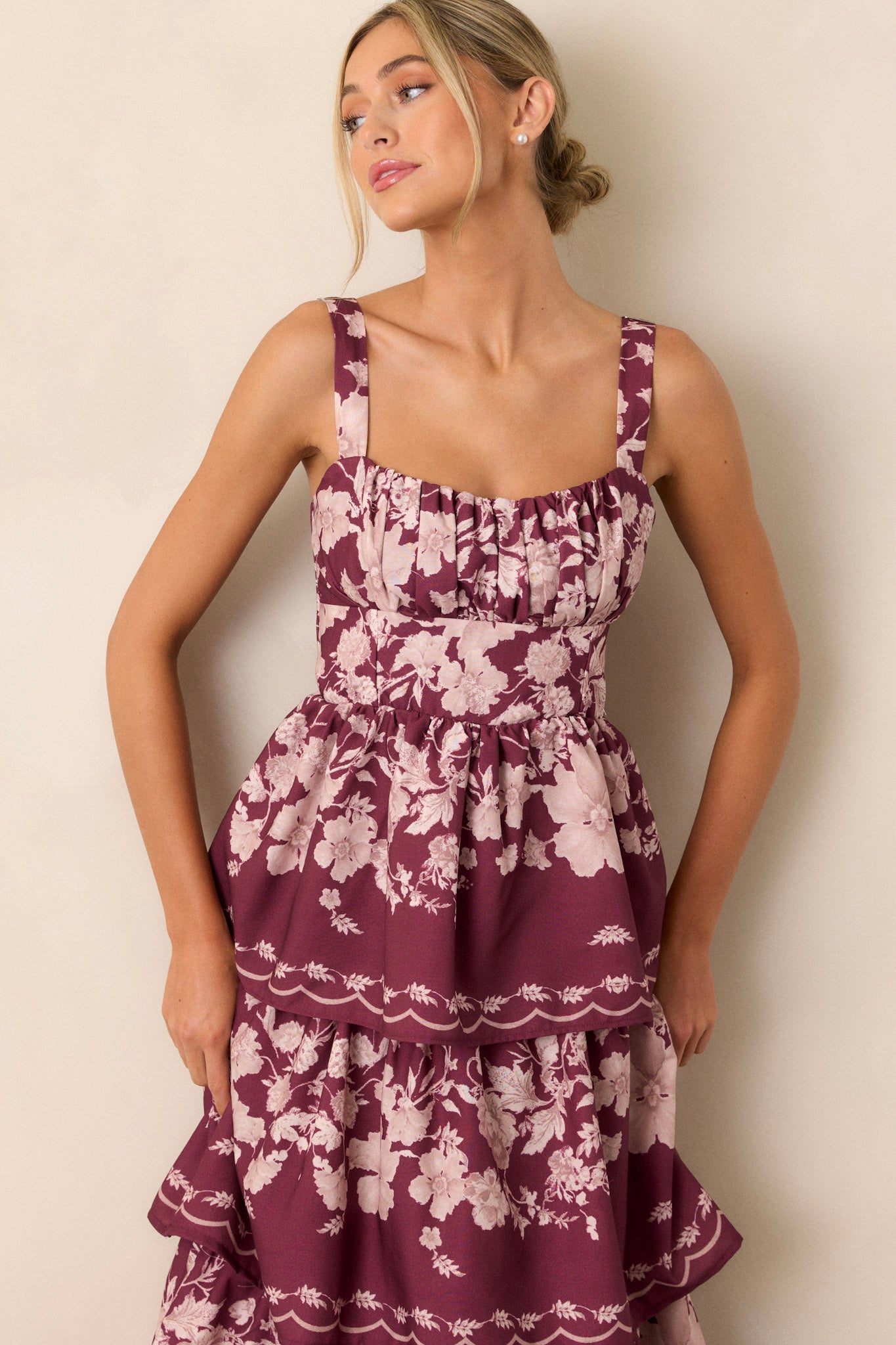 Front angled view of the wine dress featuring four flowy tiers, adjustable straps, and a back functional zipper