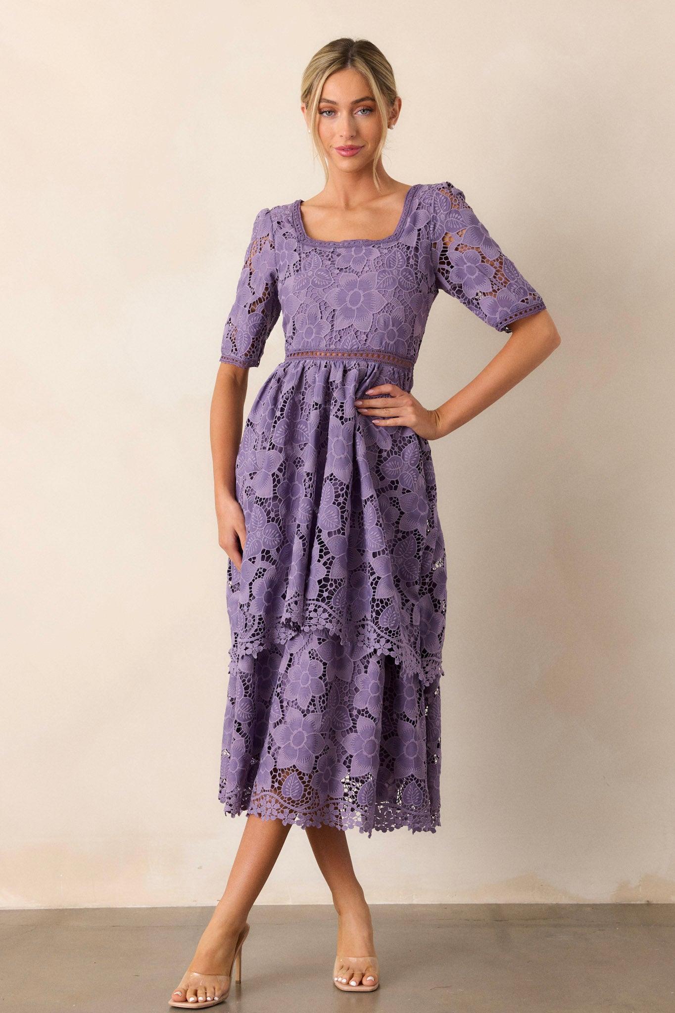 This lilac dress features a square neckline, a lace floral design, a lace cutout waist design, a tiered skirt, a discrete back zipper and half sleeves.