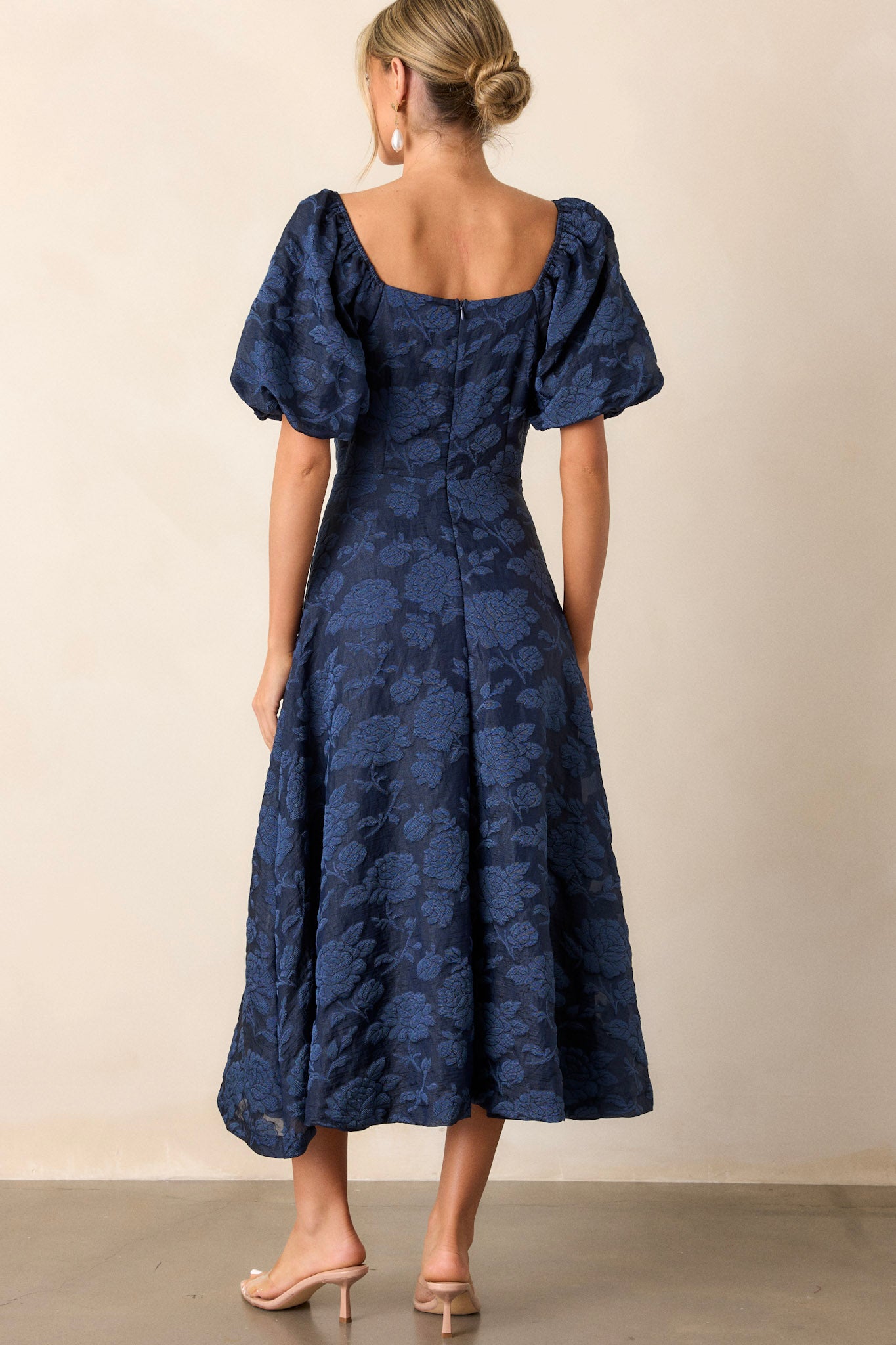 Back view of the navy floral dress highlighting the discrete back zipper and the seamless fit of the bodice.