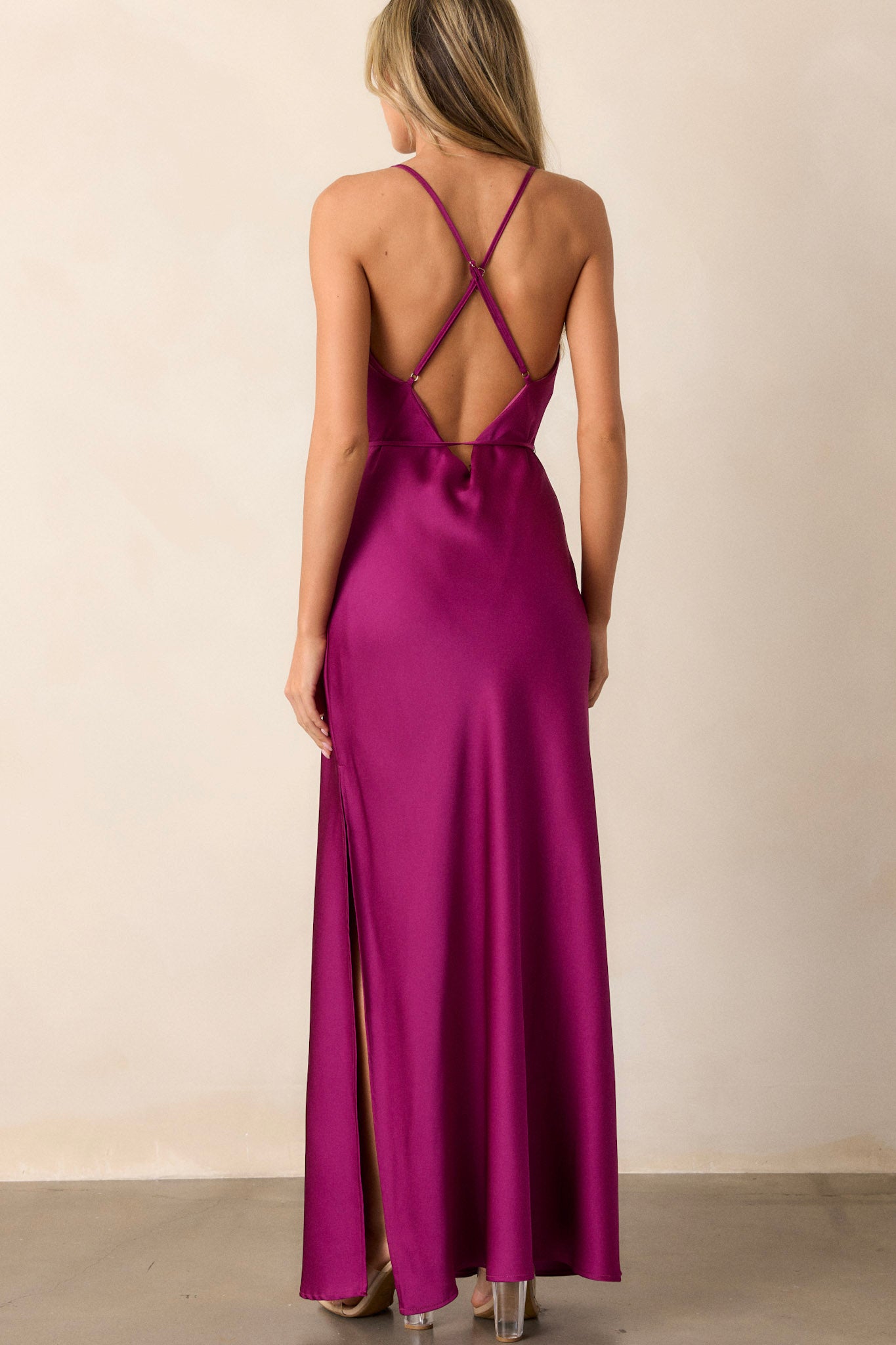 Back view of the magenta dress highlighting the adjustable straps, the smooth satin material, and the fit of the dress, with a glimpse of the self-tie belt at the waist.