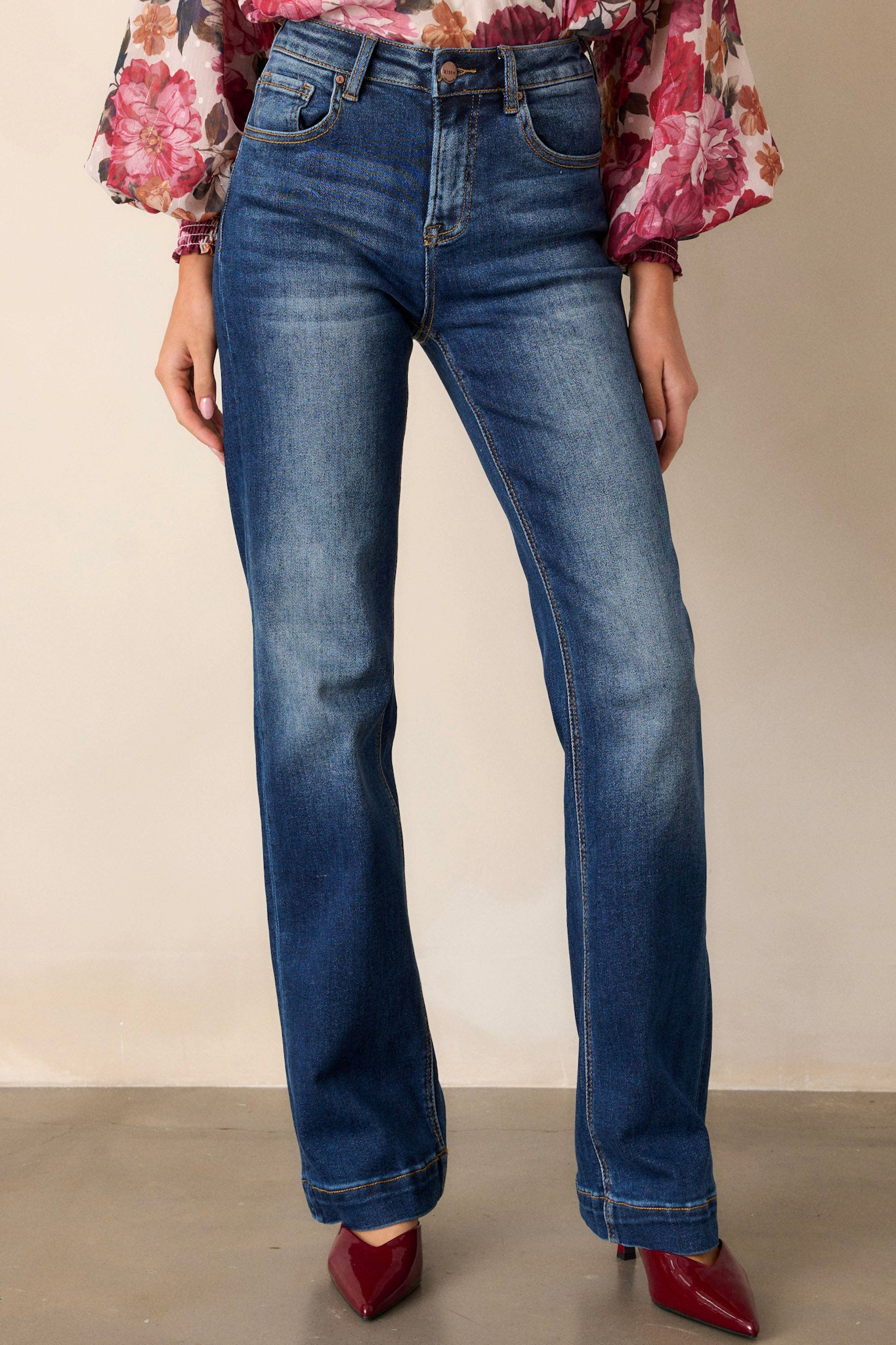 These dark wash jeans feature a high waisted design, functional belt loops, functional hip and back pockets, a dark wash design with faded thighs and knees and a straight leg.