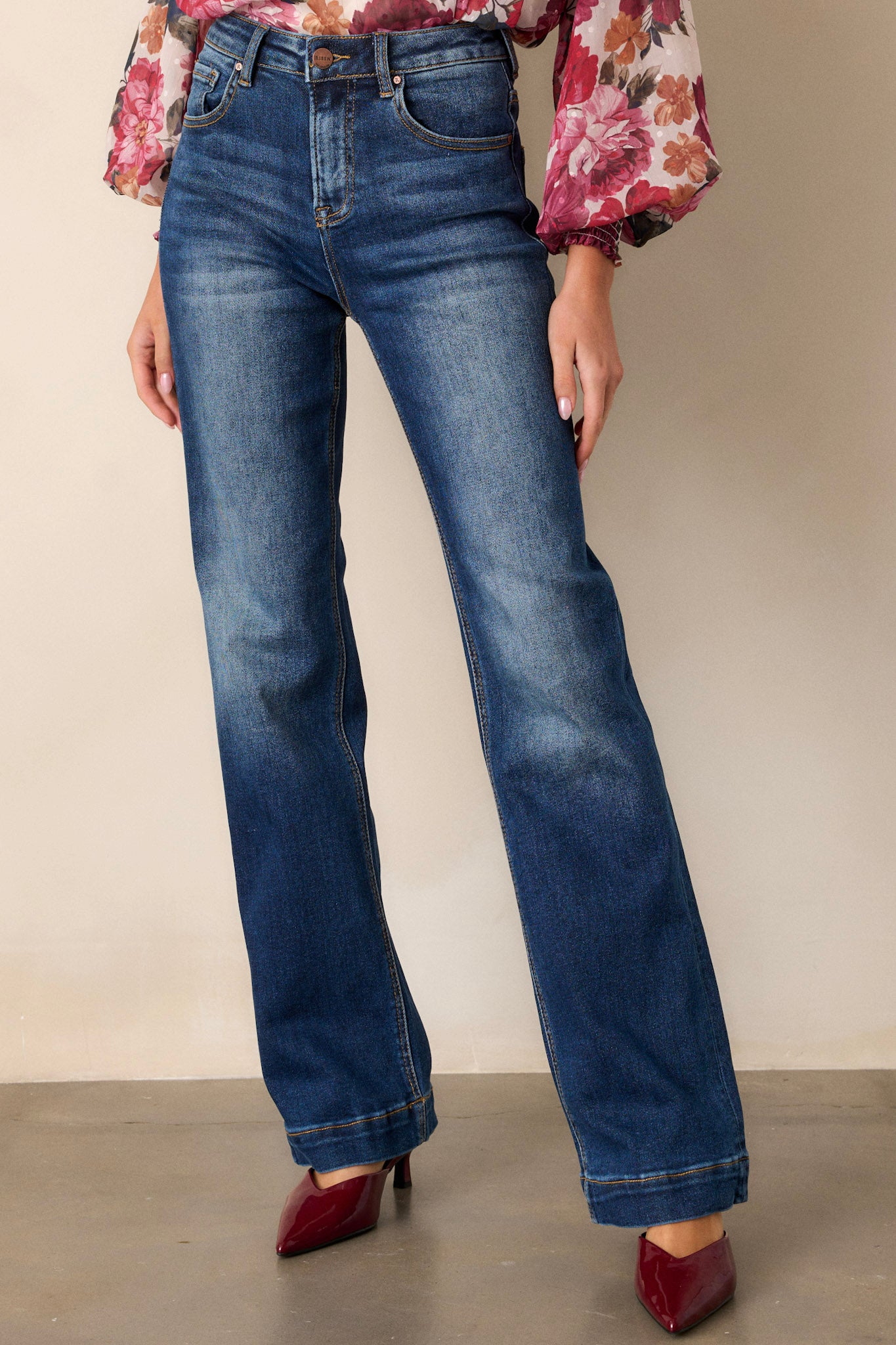 Front angled view of dark wash jeans featuring a high waisted design, functional belt loops, faded thigh and knee areas, and a straight leg fit