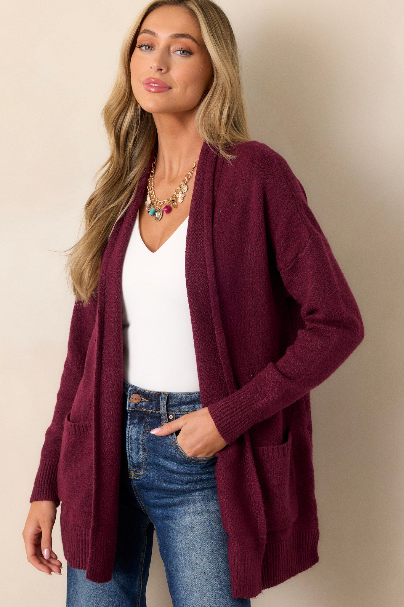 Front view of a berry cardigan featuring front pockets, an oversized cozy fit, and soft knit fabric