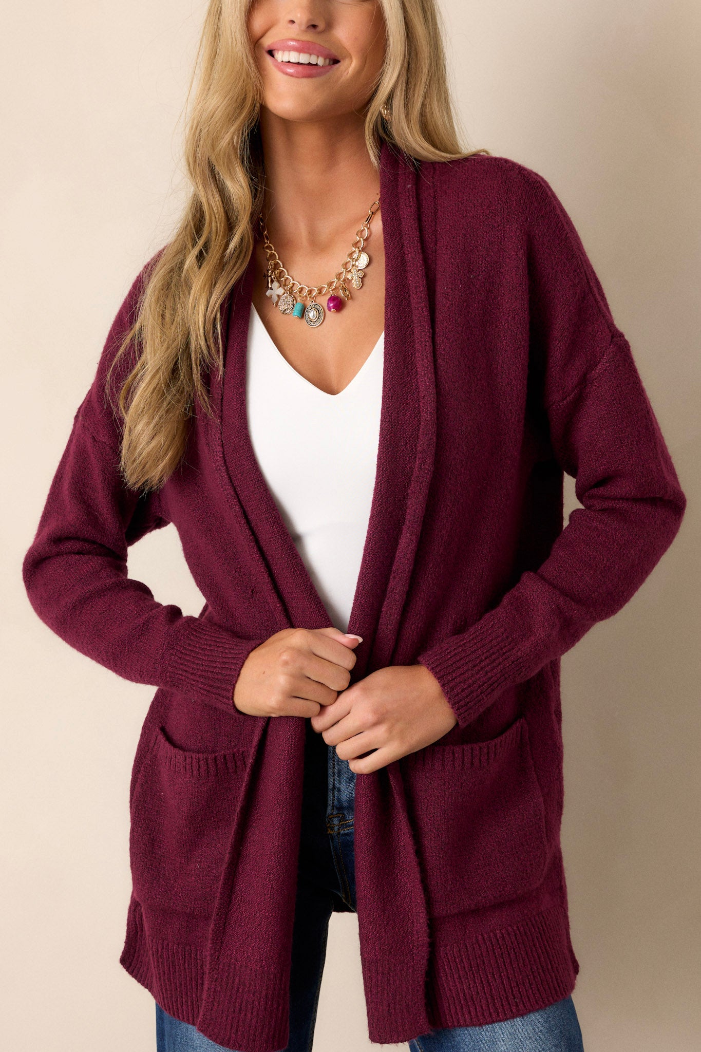 Close-up of the berry cardigan focusing on the texture of the soft knit fabric, the front pockets, and the relaxed, oversized fit.