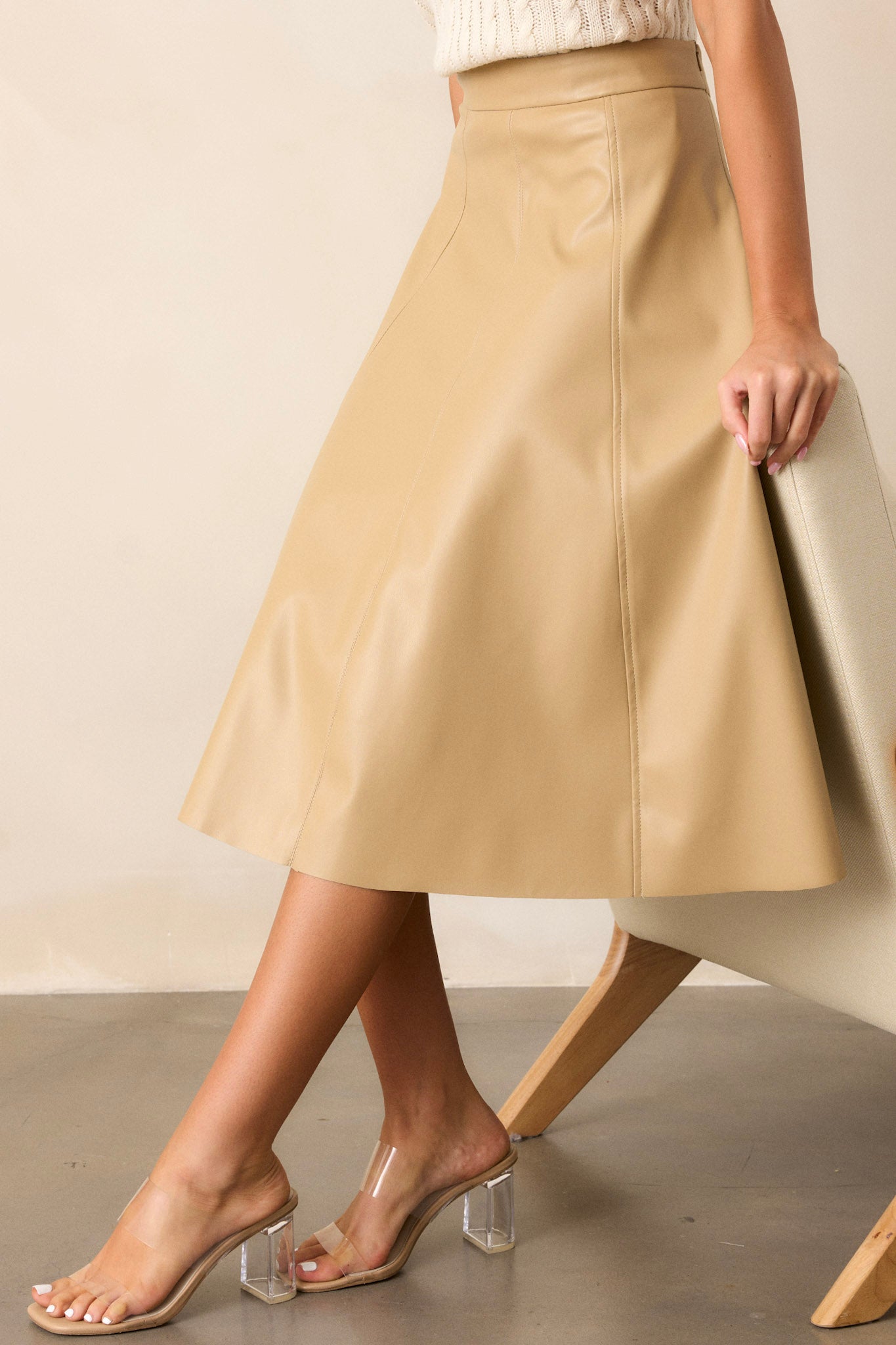 Side view of the skirt showcasing the A-line silhouette, with a focus on the side zipper and the sleek faux leather material