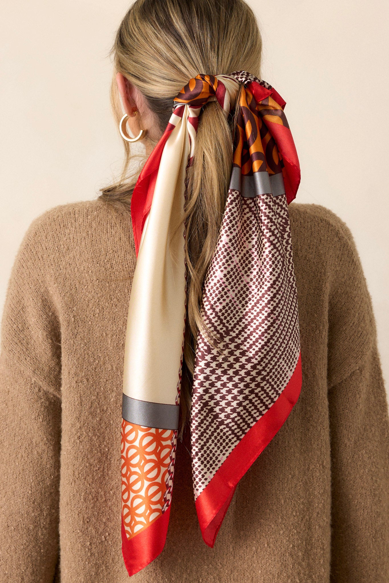 Back view of this Red scarf that features a red trim, with multi print designs, and a silky feel