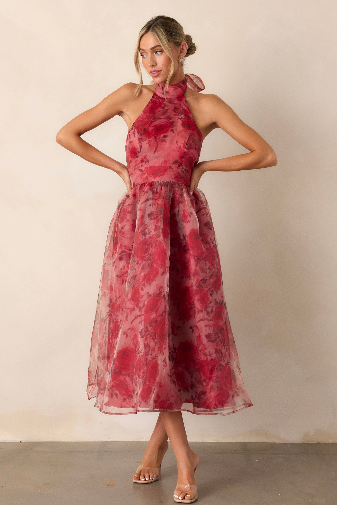 Full length view of the red floral dress featuring a halter-neck design with a slight collar, a red floral mesh pattern, and a low back, showcasing the dress's elegant flow.