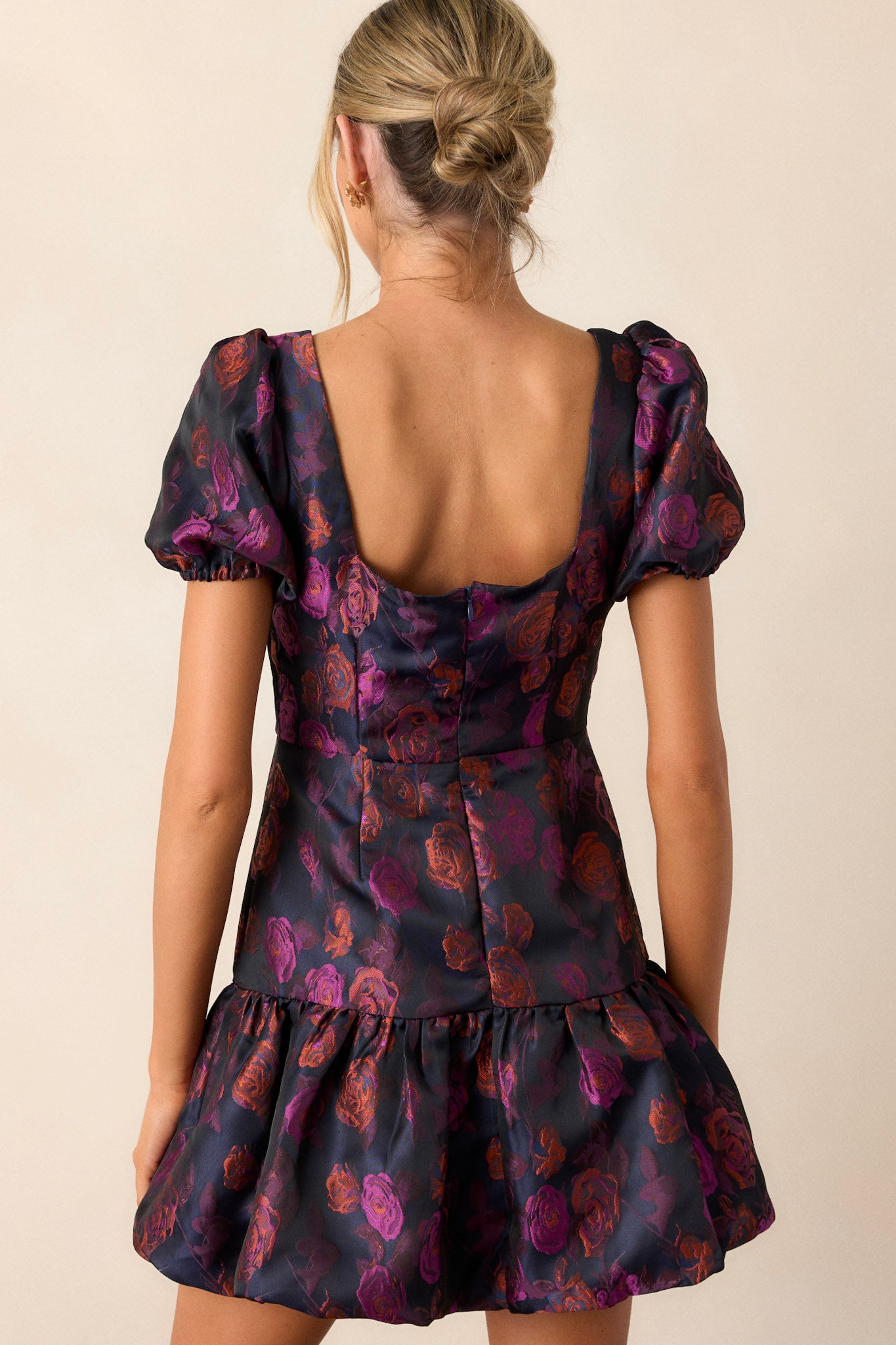 Back view of the plum dress highlighting the back functional zipper and the shape of the bottom bubble tier