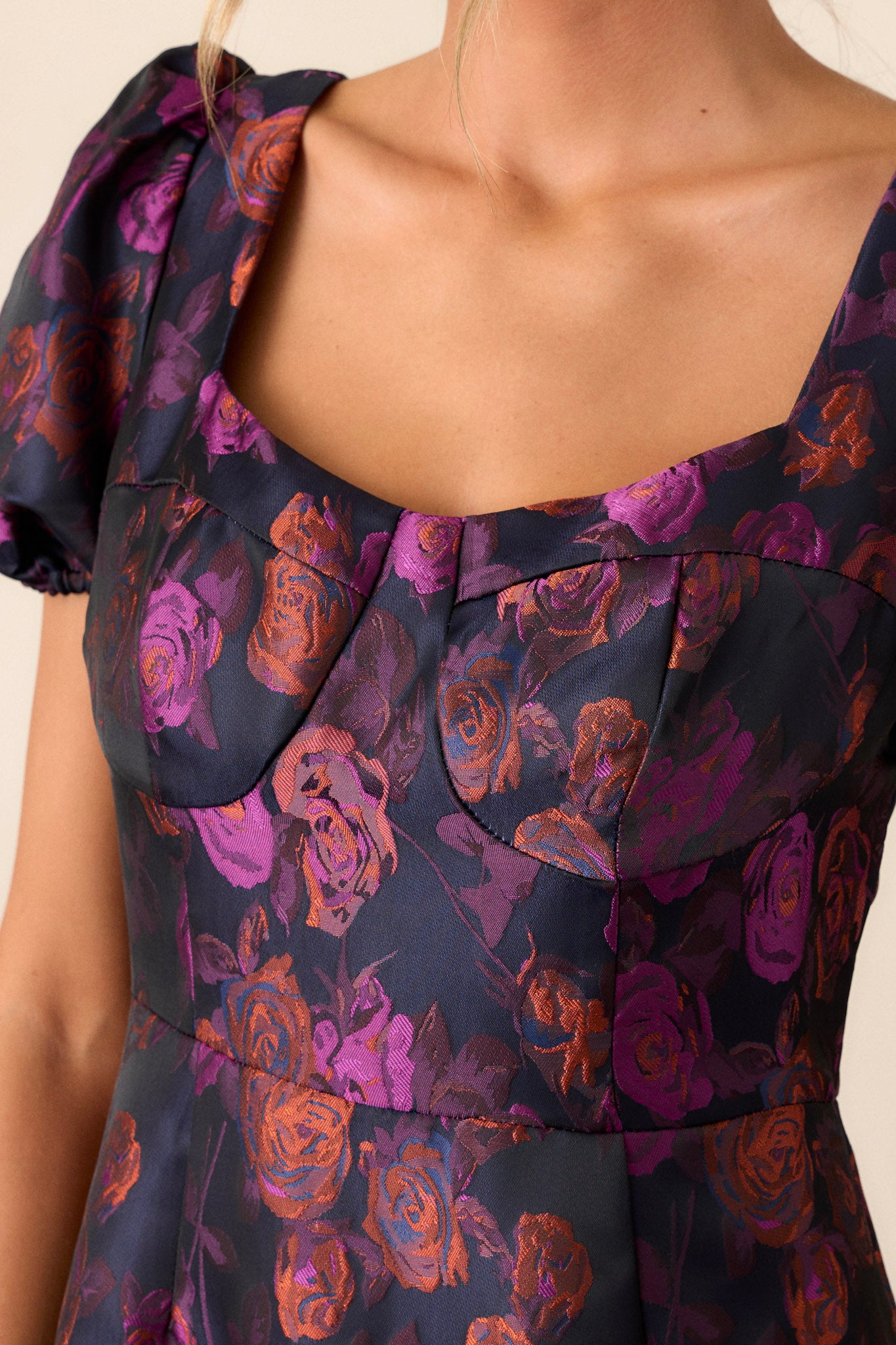 Close-up of the plum dress focusing on the sweetheart neckline, puff sleeves, and the textured design of the bottom bubble tier.