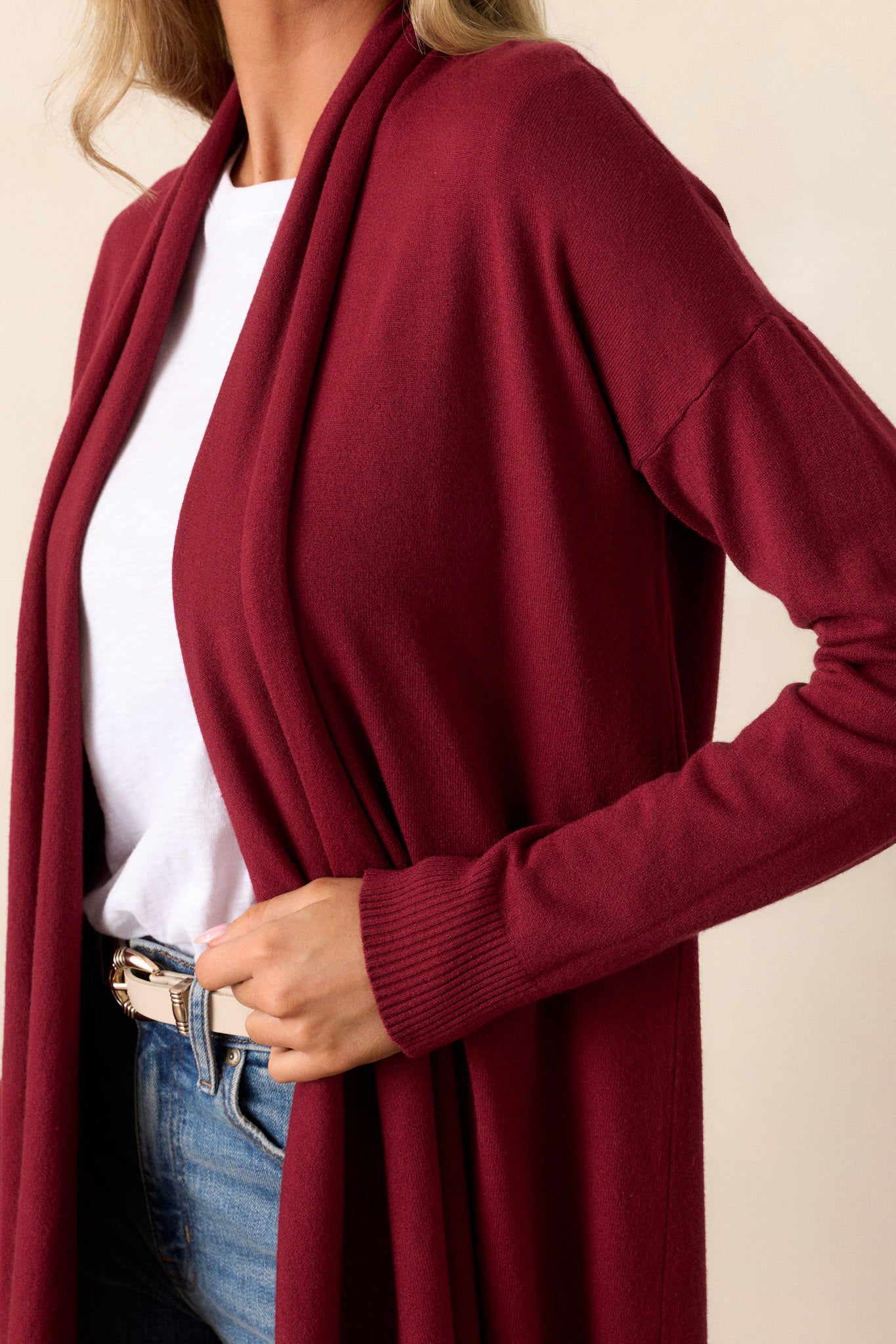 Side view of the cardigan showcasing the large slouchy folded collar, ribbed fitted cuffs, and ribbed hemline details.