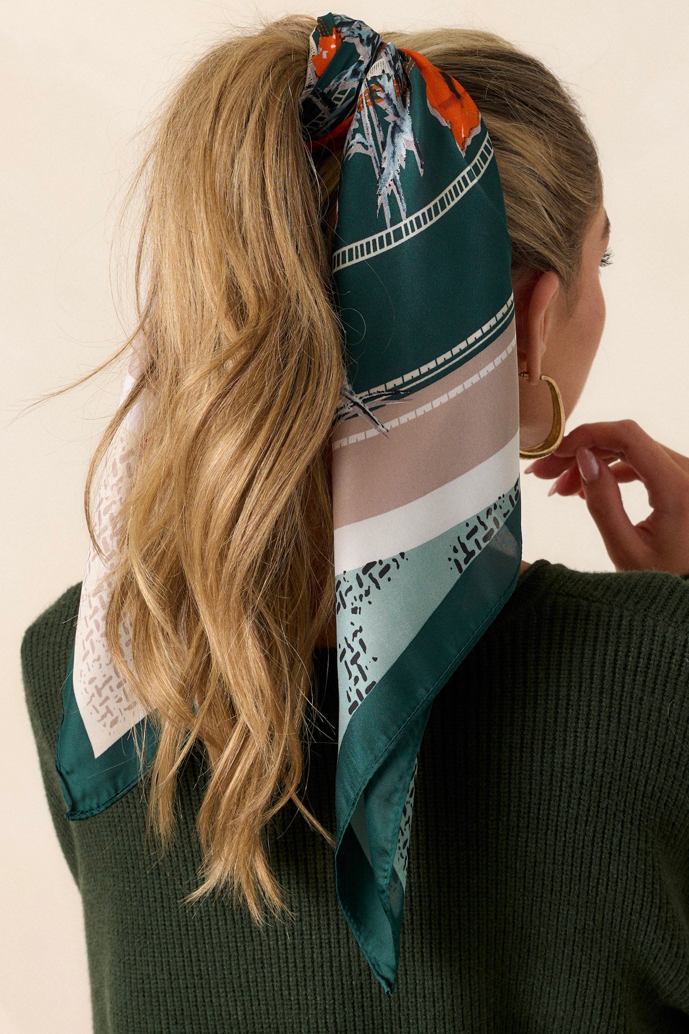 Back view of this hunter green scarf that features a green, orange and grey trim, with accent colors of blue, orange and white, and a a floral pattern design.