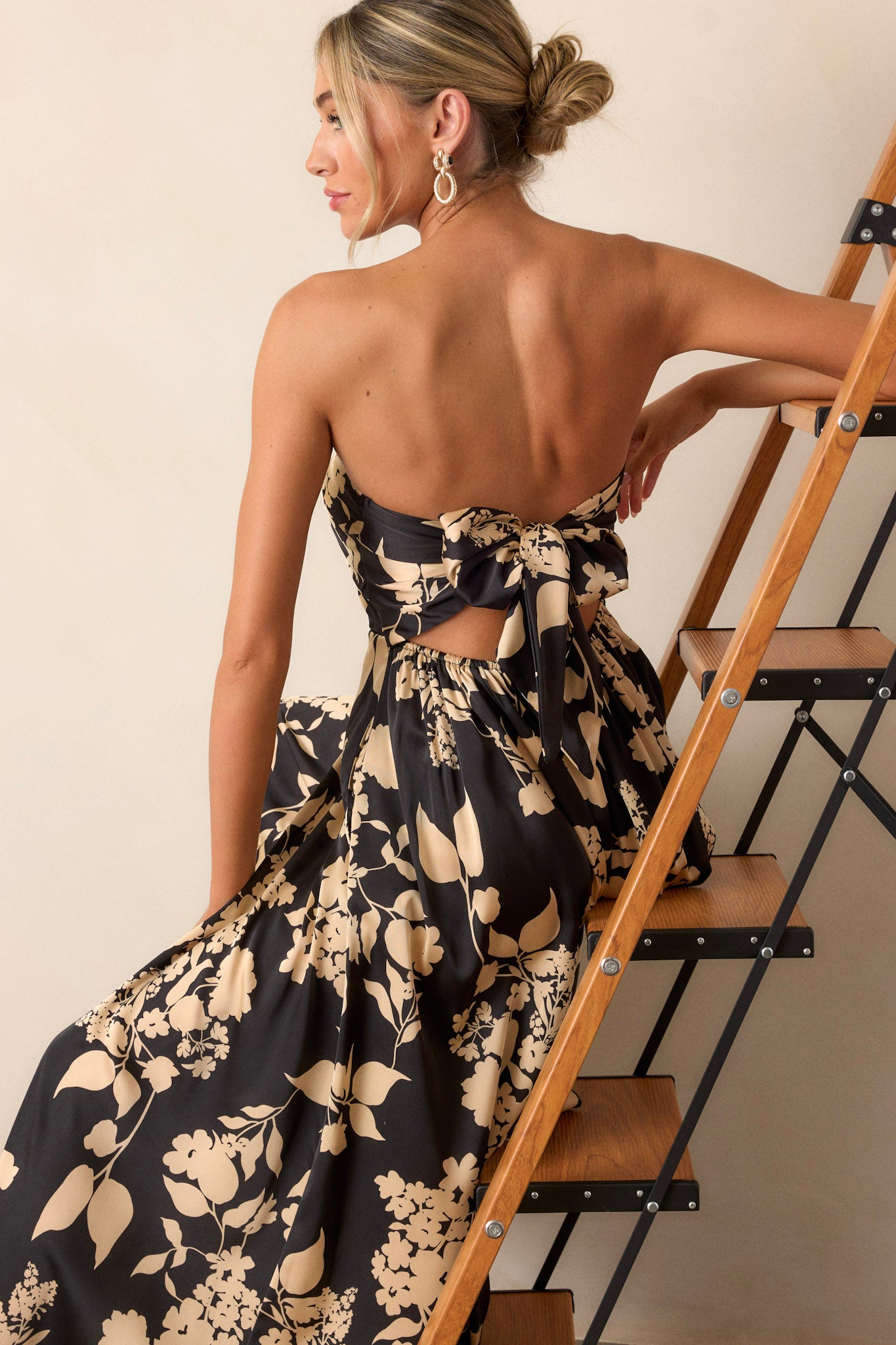 Close-up of the black jumpsuit focusing on the intricate floral design, the sleeveless cut, and the texture of the fabric.