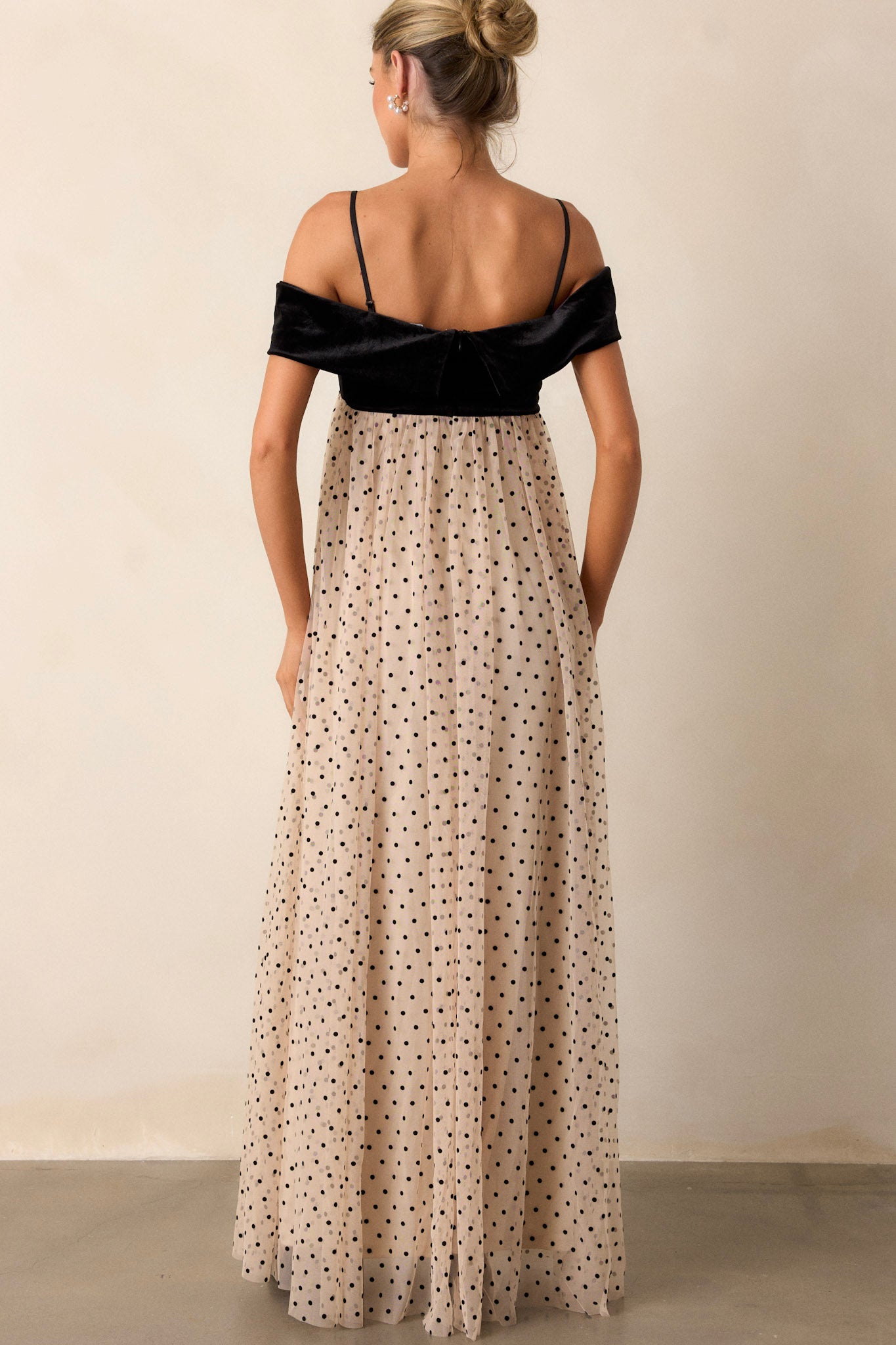 Back view of the dress highlighting the functional back zipper and the flowing polka dot skirt cascading from the waist.