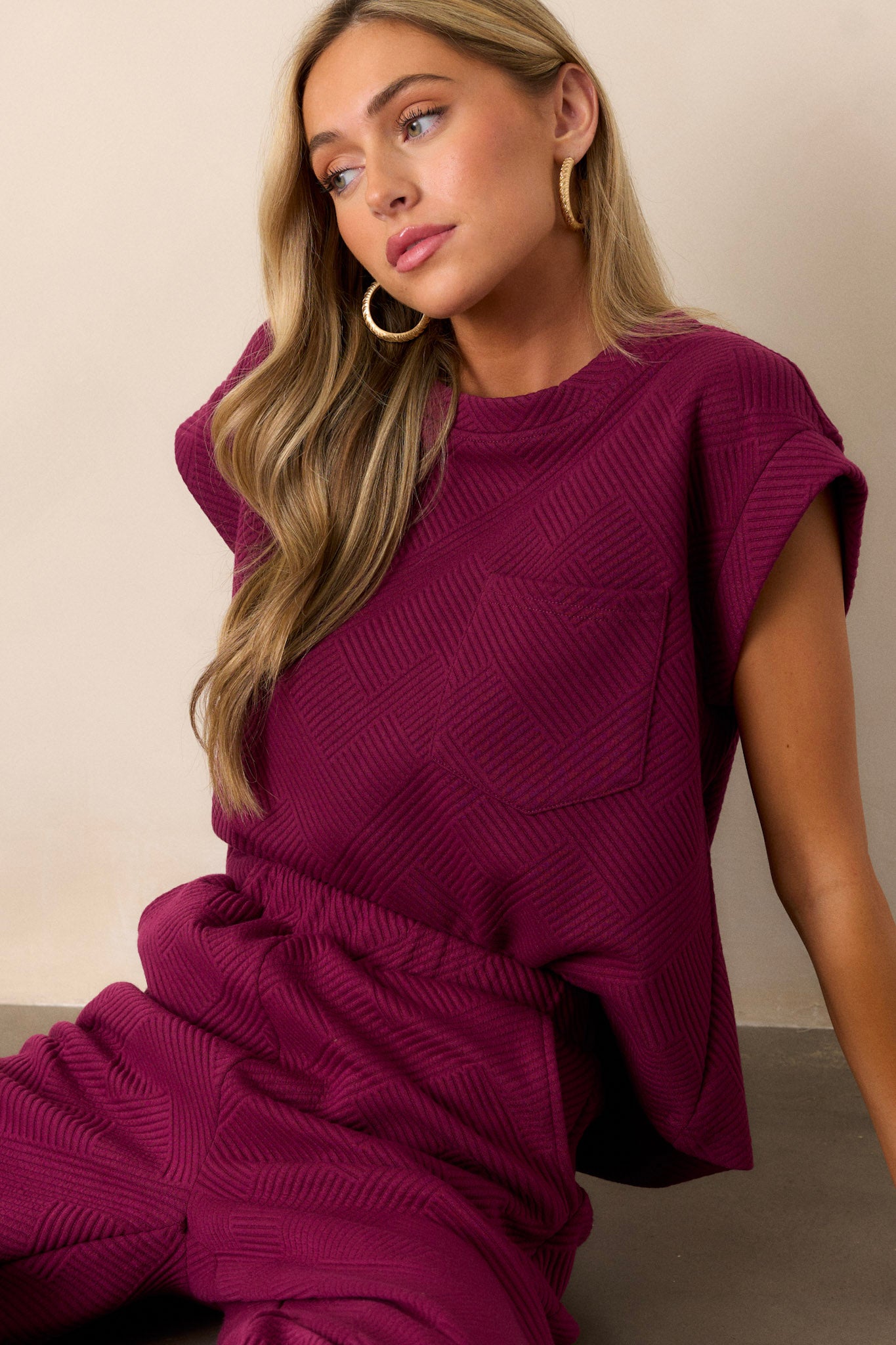 This sangria purple top features crew neckline, functional breast pocket, and cuffed short sleeves.