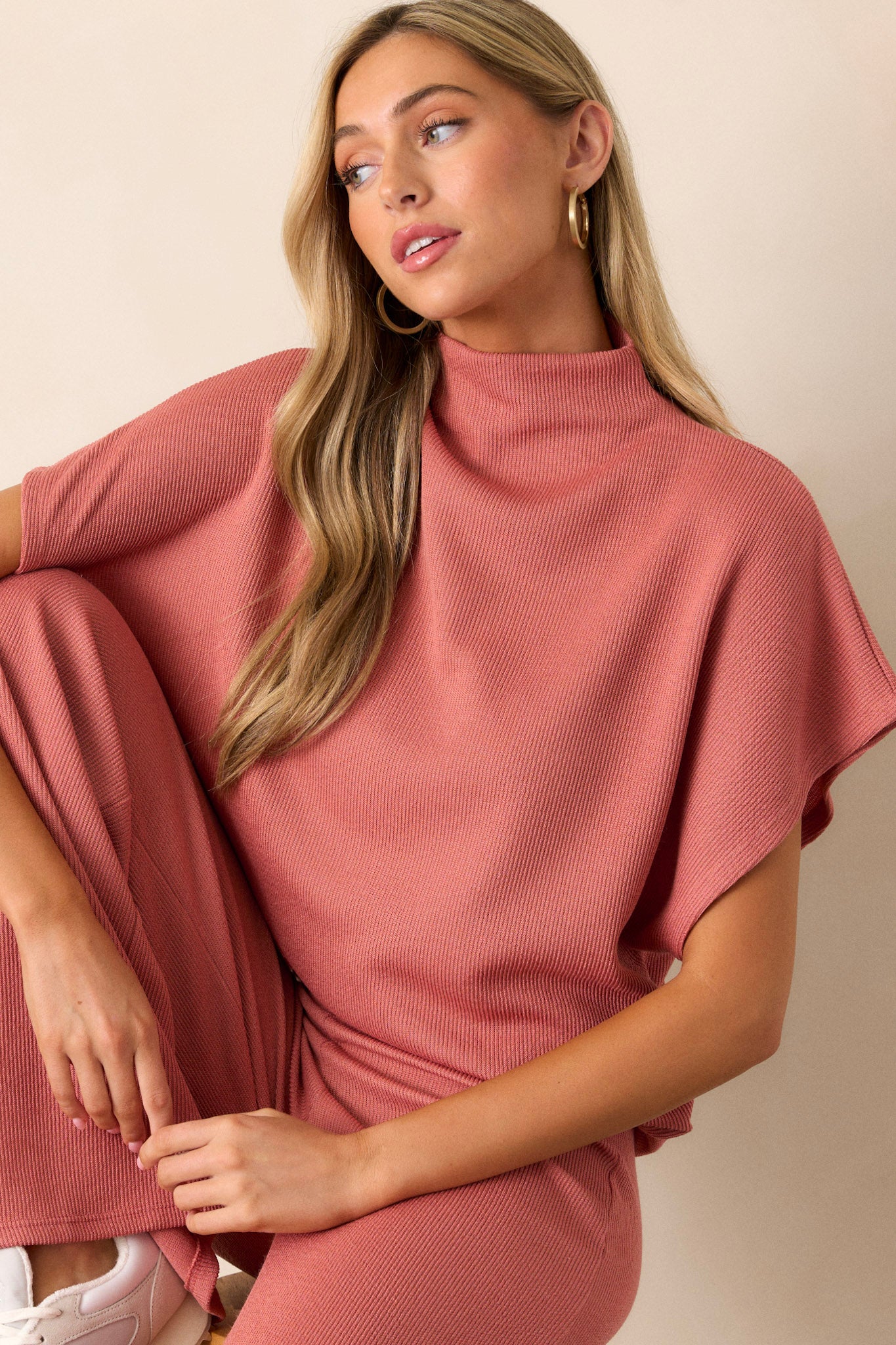 This coral top features a turtleneck, a knit towel like texture on the outside, a soft smooth inside, cinching in the hips and short flowy sleeves.