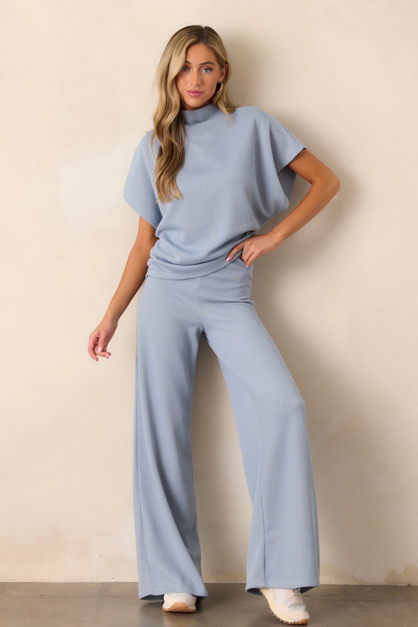 Full body view of these blue knitted pants that feature an elastic waist band, a high waisted design, a knit towel like texture on the outside, a soft inside and a wide leg.