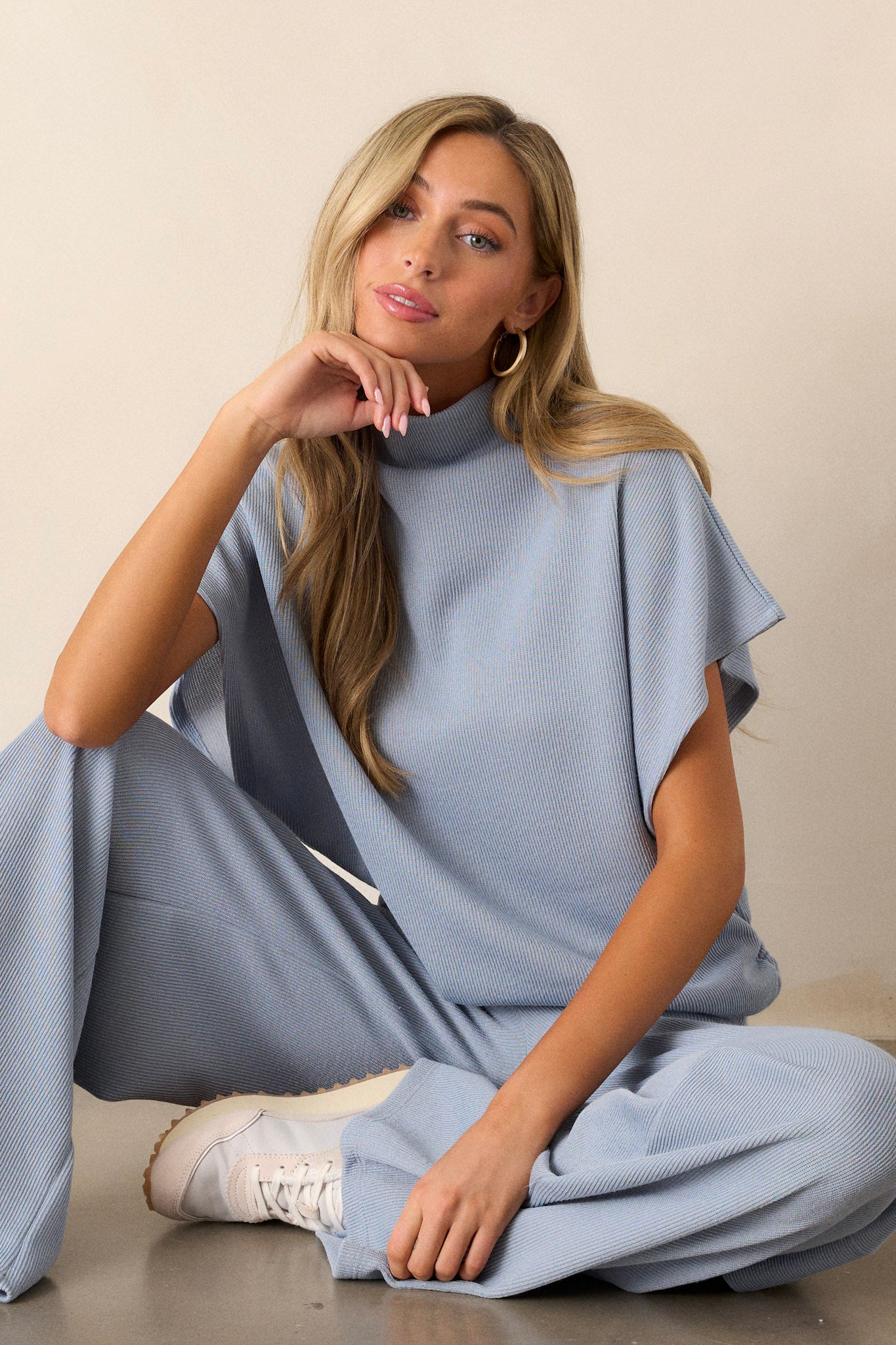 This blue top features a turtleneck, a knit towel like texture on the outside, a soft smooth inside, cinching in the hips and short flowy sleeves.