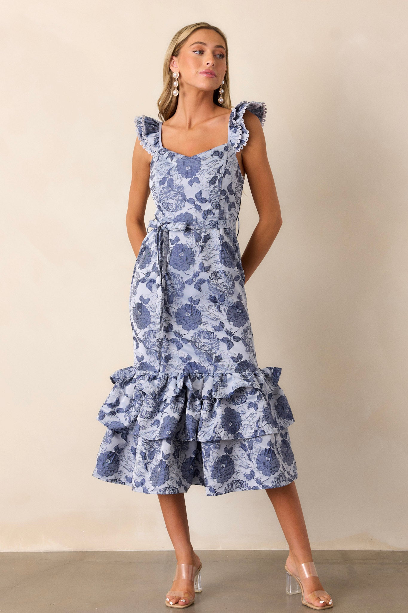 Full length view of the dress featuring a scoop neckline, a ruffled puffy bottom, a functional tie at the back