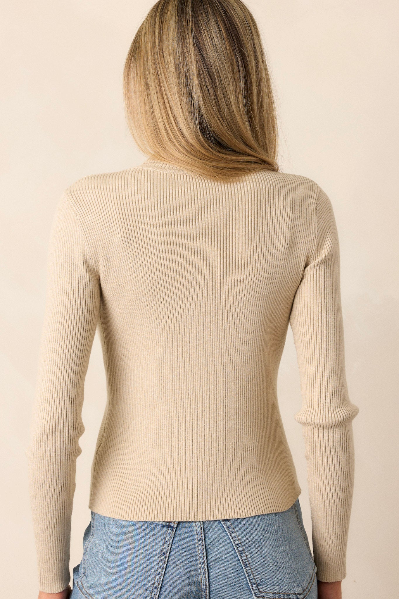 Back view of a khaki sweater featuring a ribbed texture throughout, a turtleneck, and long sleeves.