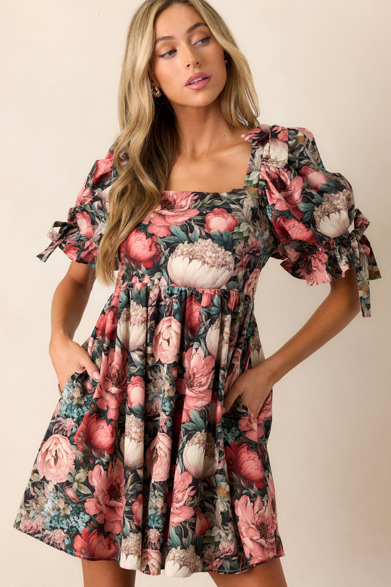 Angled view of the dress showing the puff sleeves with ties, functional side pockets, and the flowy floral tier, highlighting the overall silhouette and design.