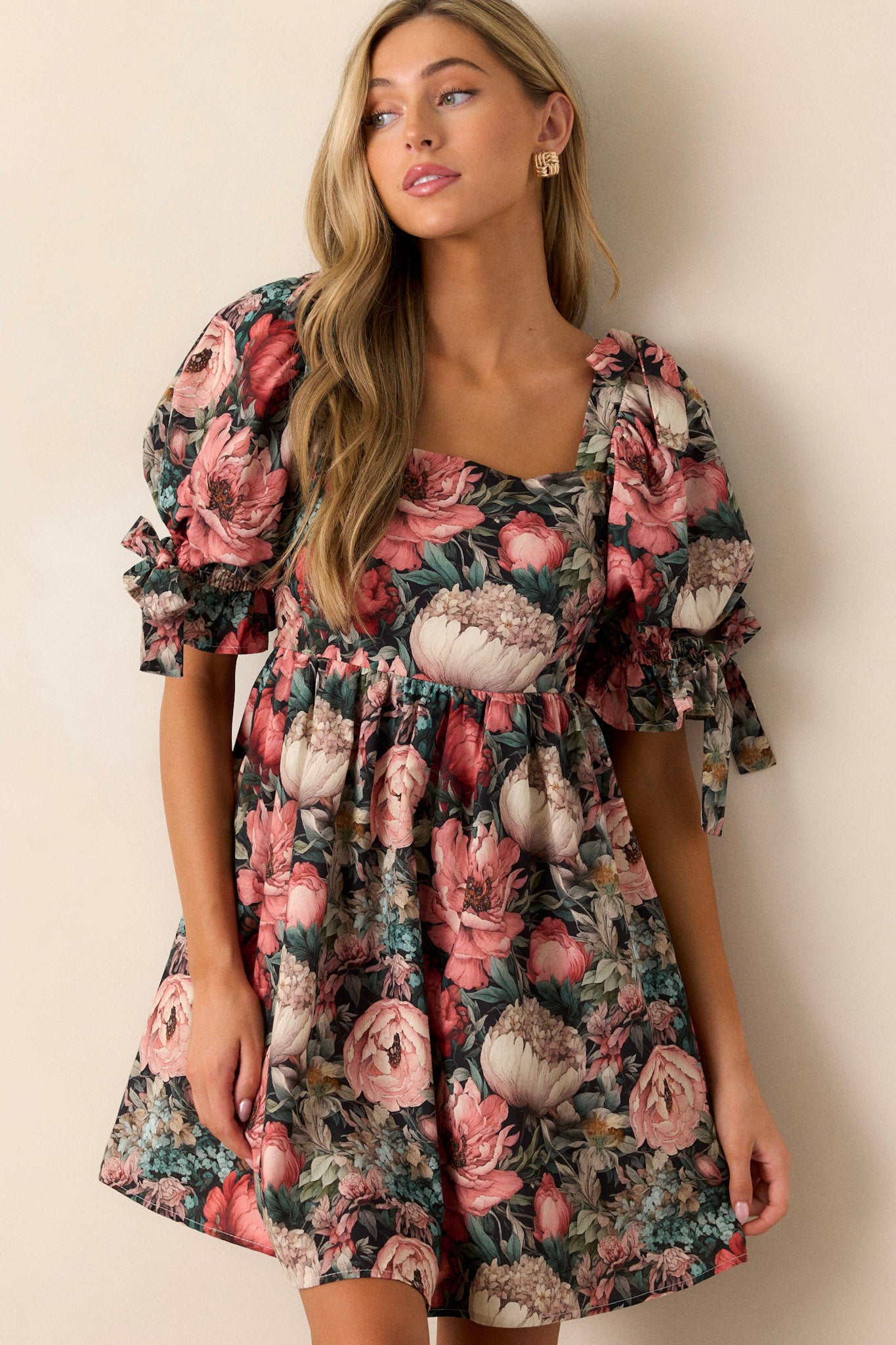 This dress features puff sleeves with ties, to functional side pockets and a flowy floral tier.