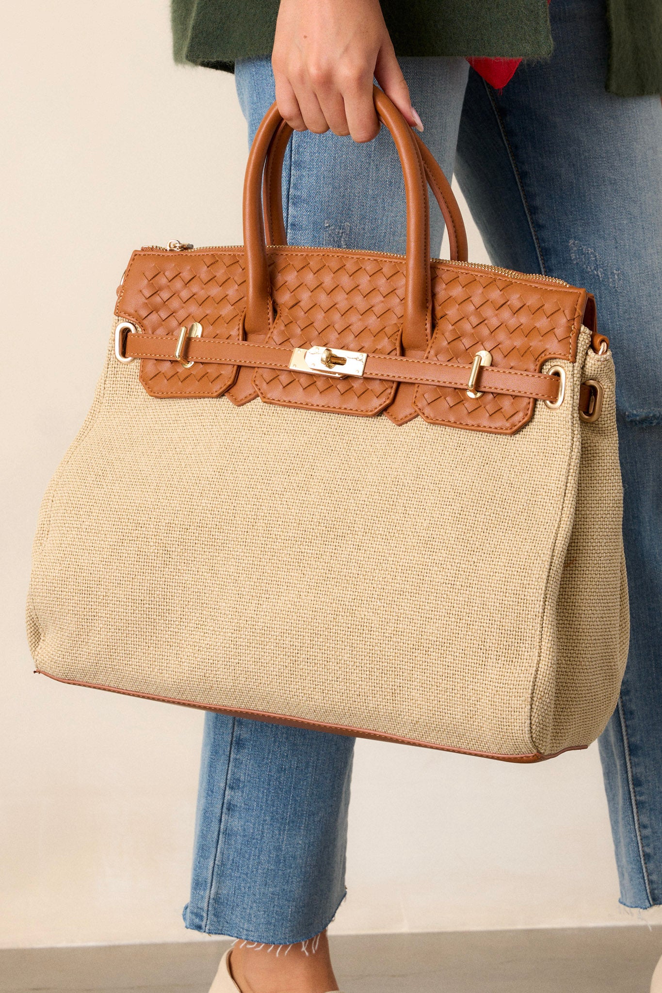 Angled view of the tan structured tote bag showcasing the beige woven body, tan woven faux leather top, gold hardware, and tan handles, with a hint of the shoulder bag option