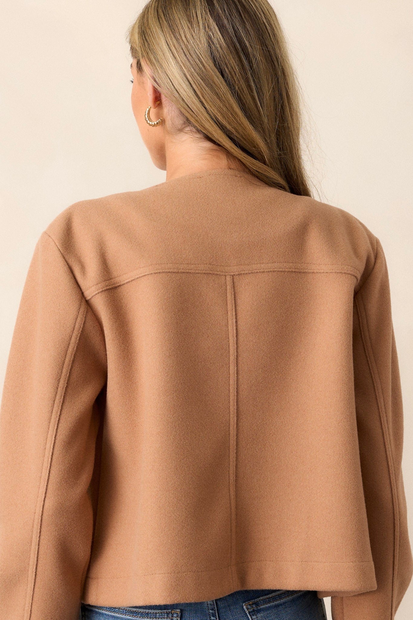 Back view of the camel brown jacket highlighting the cozy tweed fabric and the simple, clean design with a scoop neck.