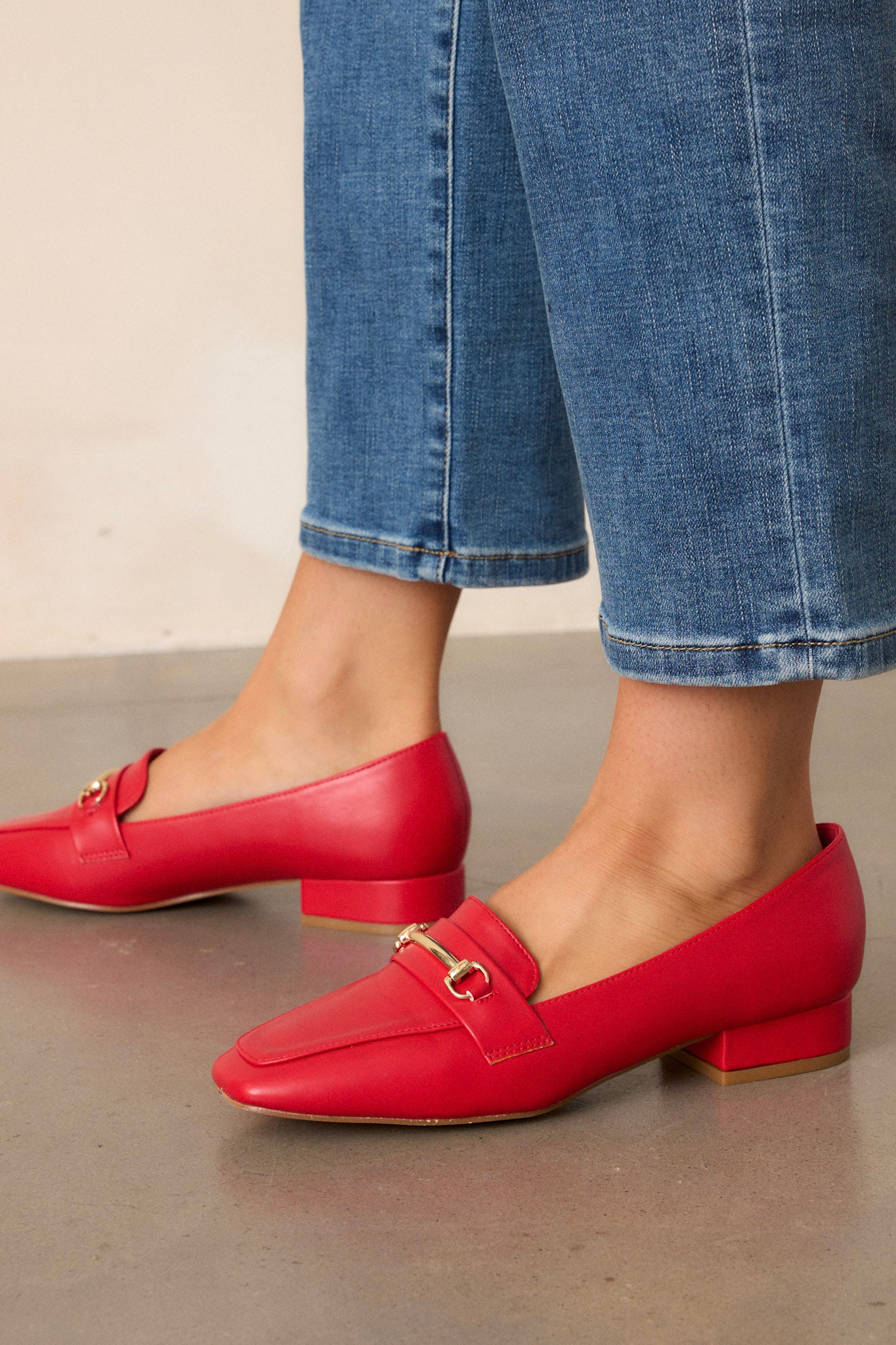 These red loafers feature a slip on design, a small heel, a square toe, and gold hardware.