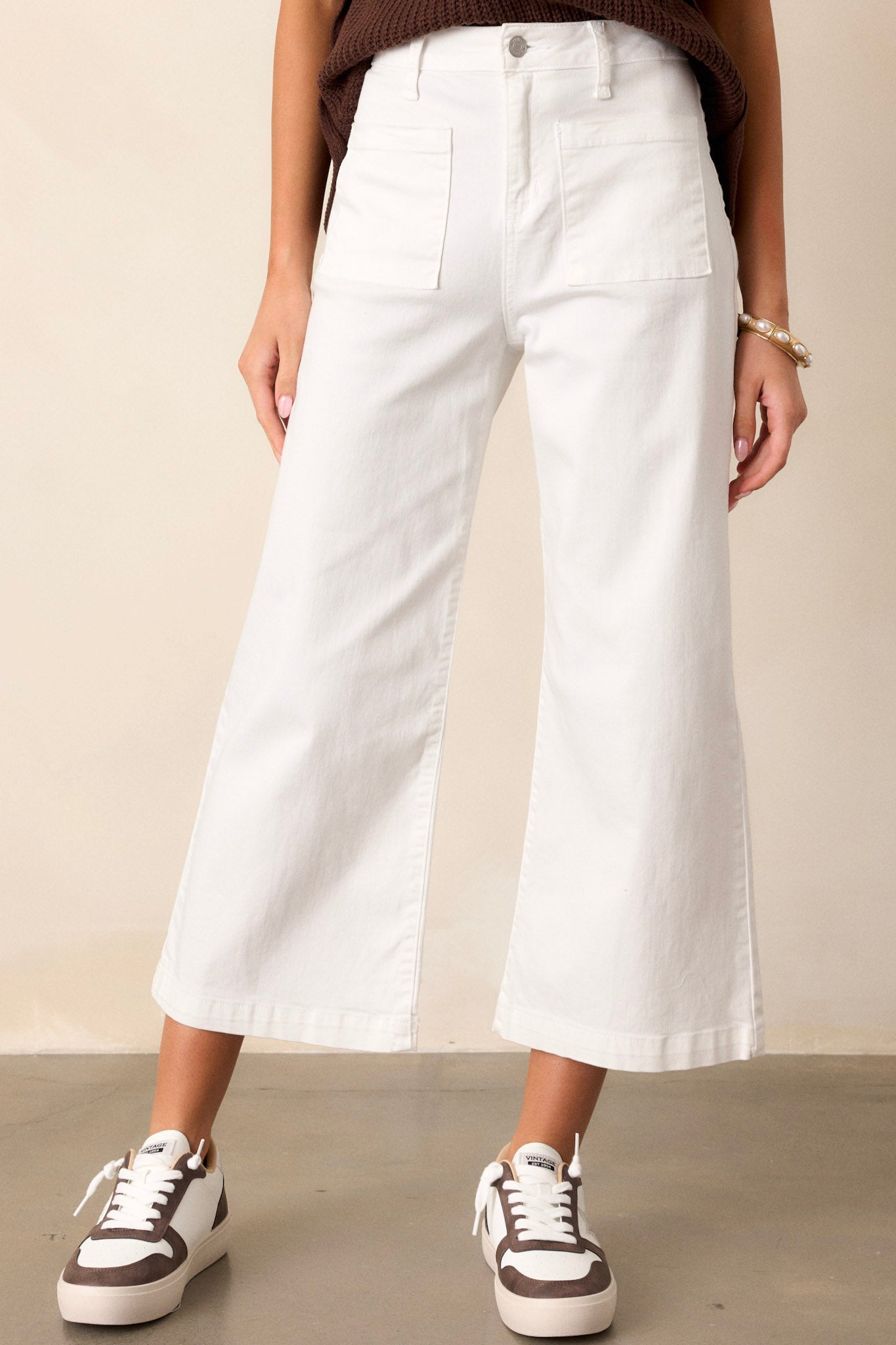 These white jeans feature a high waisted design, a button & zipper closure, belt loops, functional front & back pockets, a cropped hemline, and a flared leg.