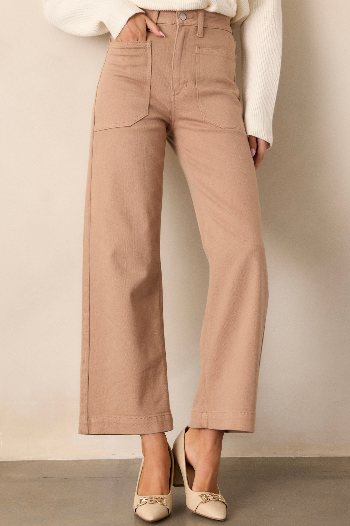 Front view of tan jeans featuring a high waisted design, button & zipper closure, belt loops, functional front & back pockets, and a wide leg.